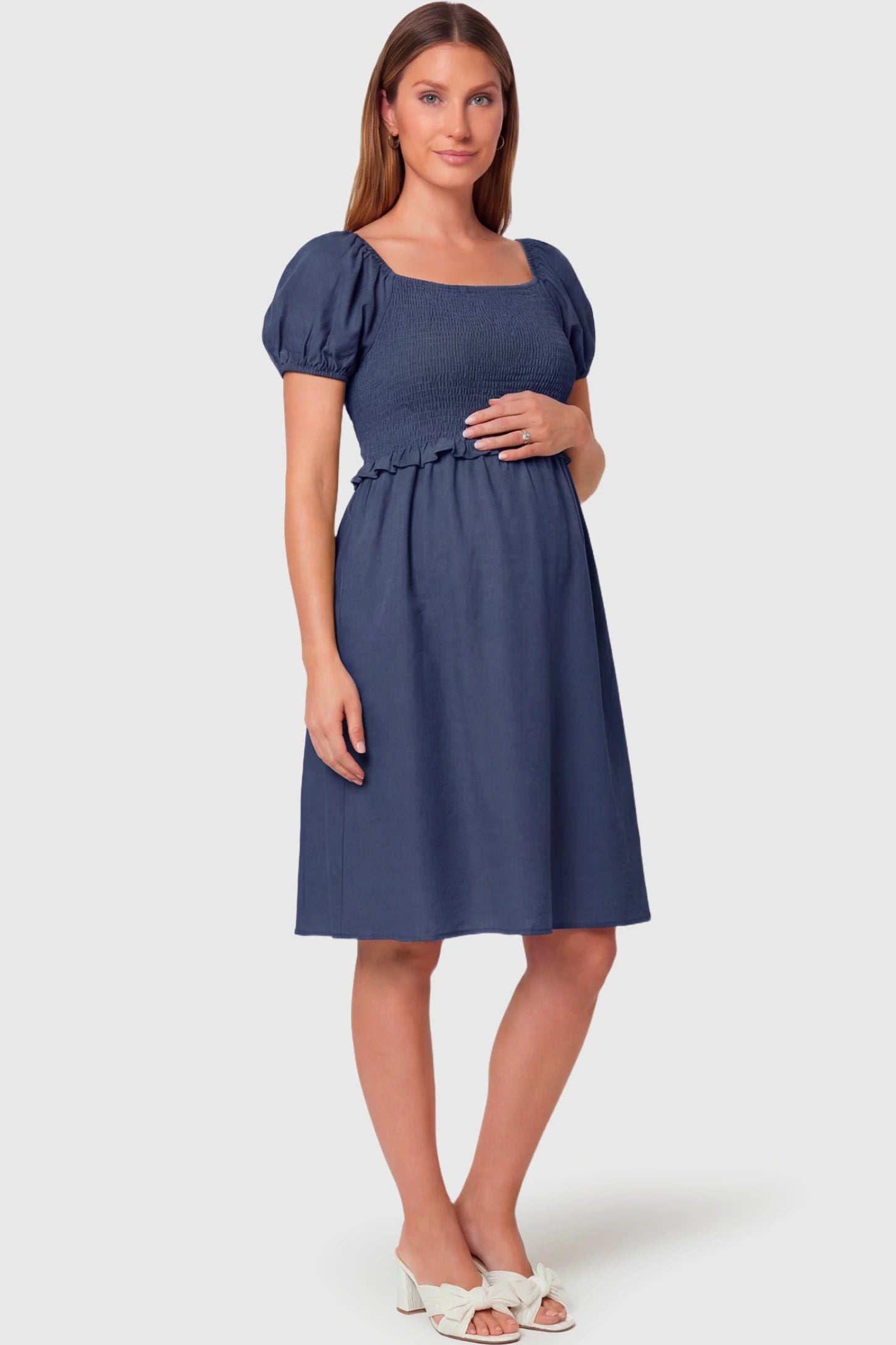 Short Puff Sleeve Empire Waist Maternity & Nursing Midi Dress Short Puff Sleeve Empire Waist Maternity & Nursing Midi Dress in navy blue featuring a square neck, smocked bodice, and A-line silhouette on a pregnant model.