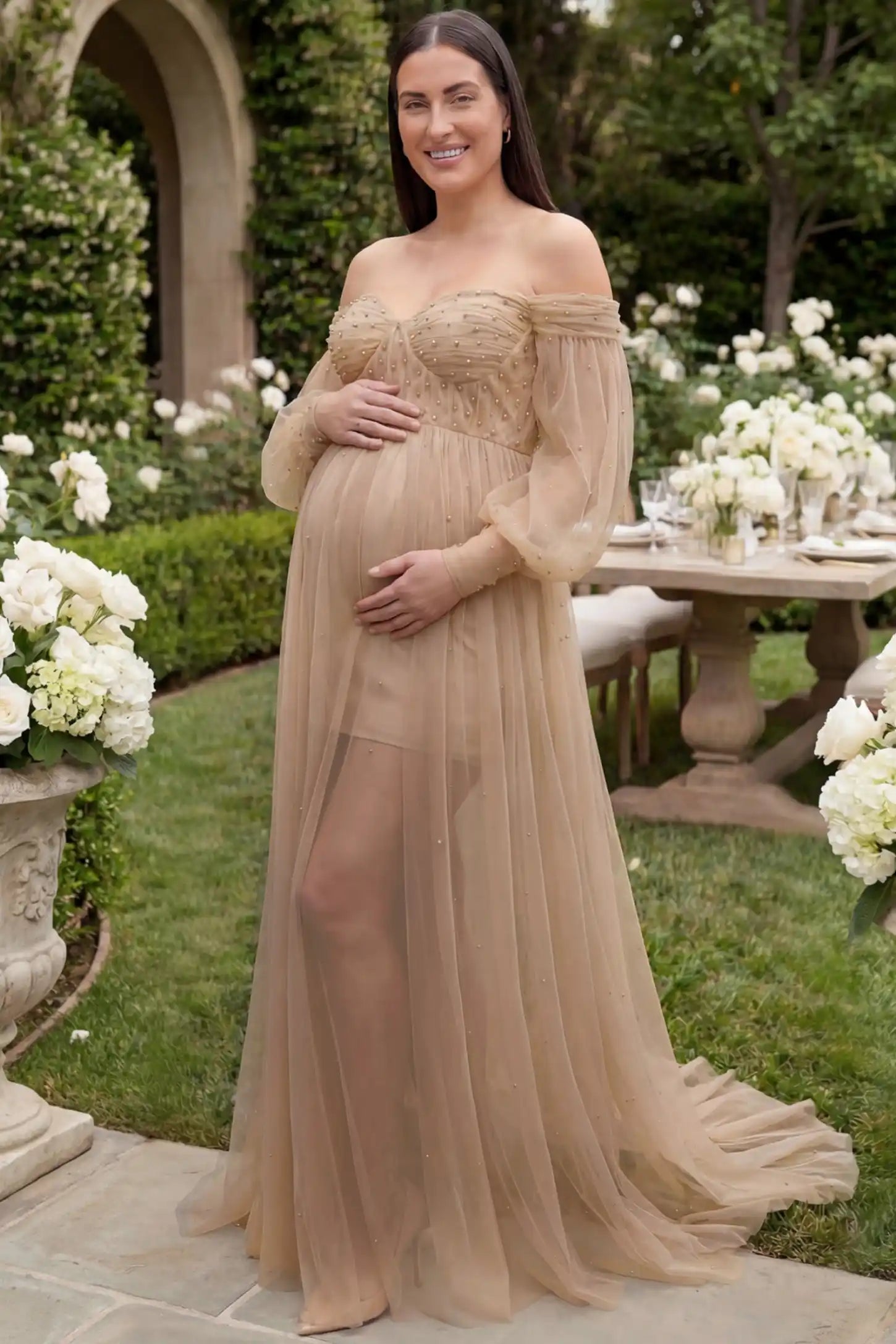 Off-Shoulder Empire Waist Maternity Gown Off-Shoulder Empire Waist Maternity Gown in camel featuring a sweetheart neckline and flowy A-line silhouette on a plus size pregnant model, front view.