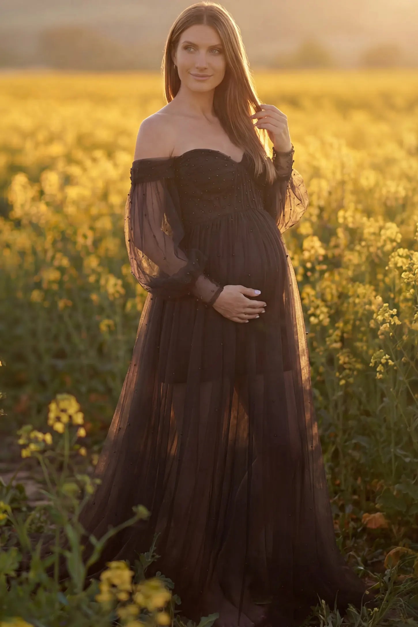Off-Shoulder Empire Waist Maternity Gown Off-Shoulder Empire Waist Maternity Gown in black featuring a sweetheart neckline and flowy A-line silhouette on a pregnant model, front view.