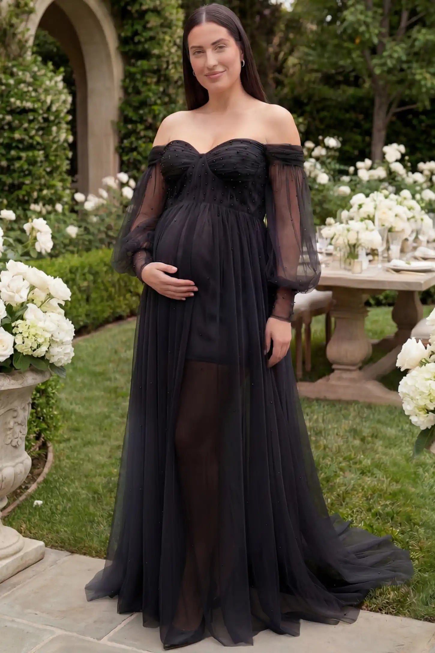 Off-Shoulder Empire Waist Maternity Gown Off-Shoulder Empire Waist Maternity Gown in black featuring a sweetheart neckline and flowy A-line silhouette on a plus size pregnant model, front view.