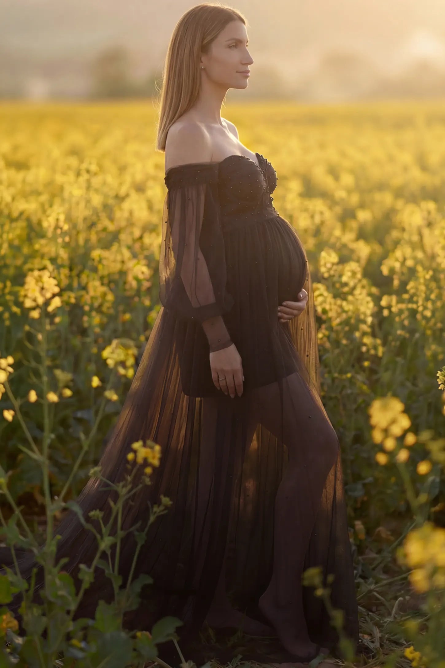 Off-Shoulder Empire Waist Maternity Gown Off-Shoulder Empire Waist Maternity Gown in black featuring a sweetheart neckline and flowy A-line silhouette on a pregnant model, side view.