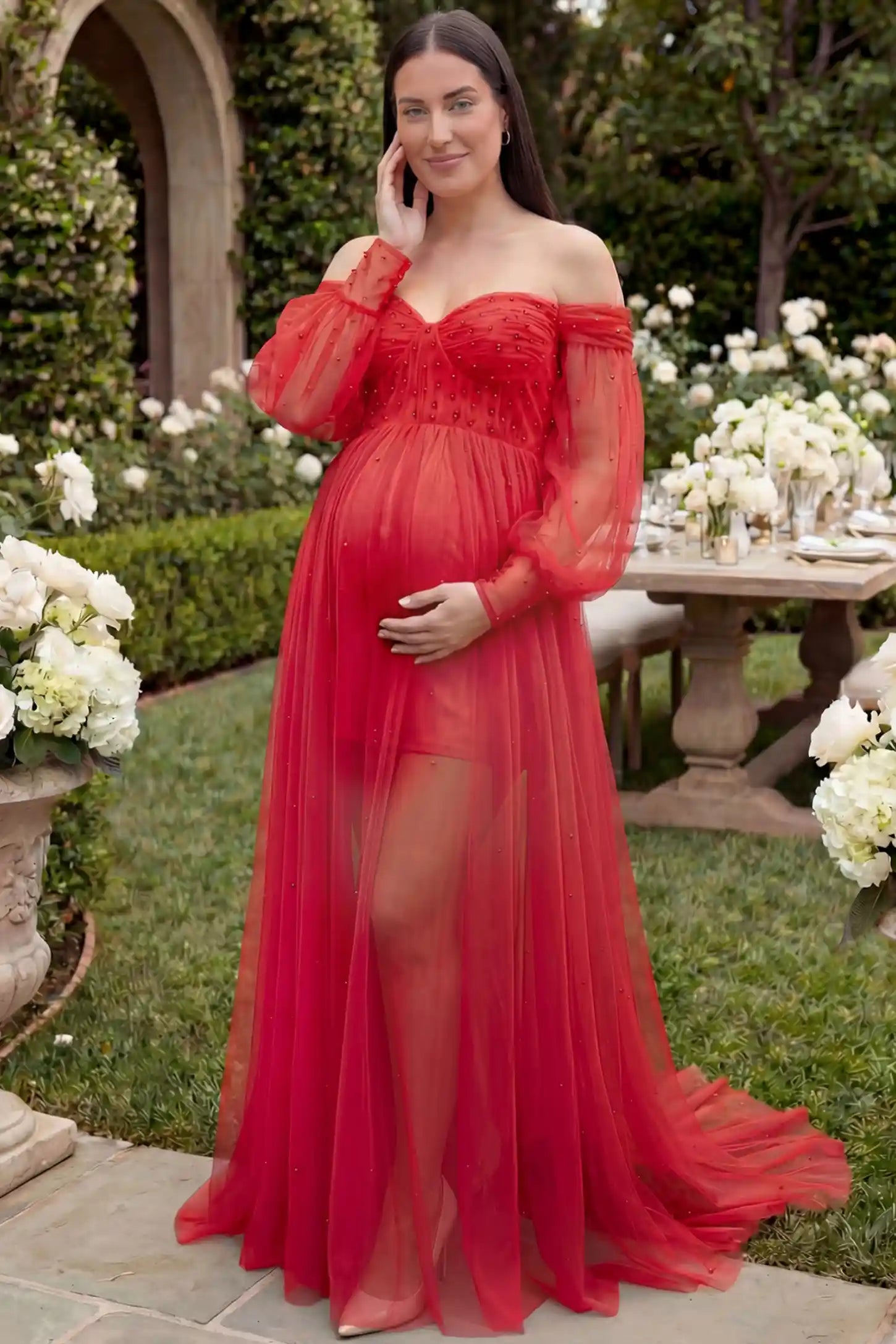 Off-Shoulder Empire Waist Maternity Gown Off-Shoulder Empire Waist Maternity Gown in red featuring a sweetheart neckline and flowy A-line silhouette on a plus size pregnant model, front view.