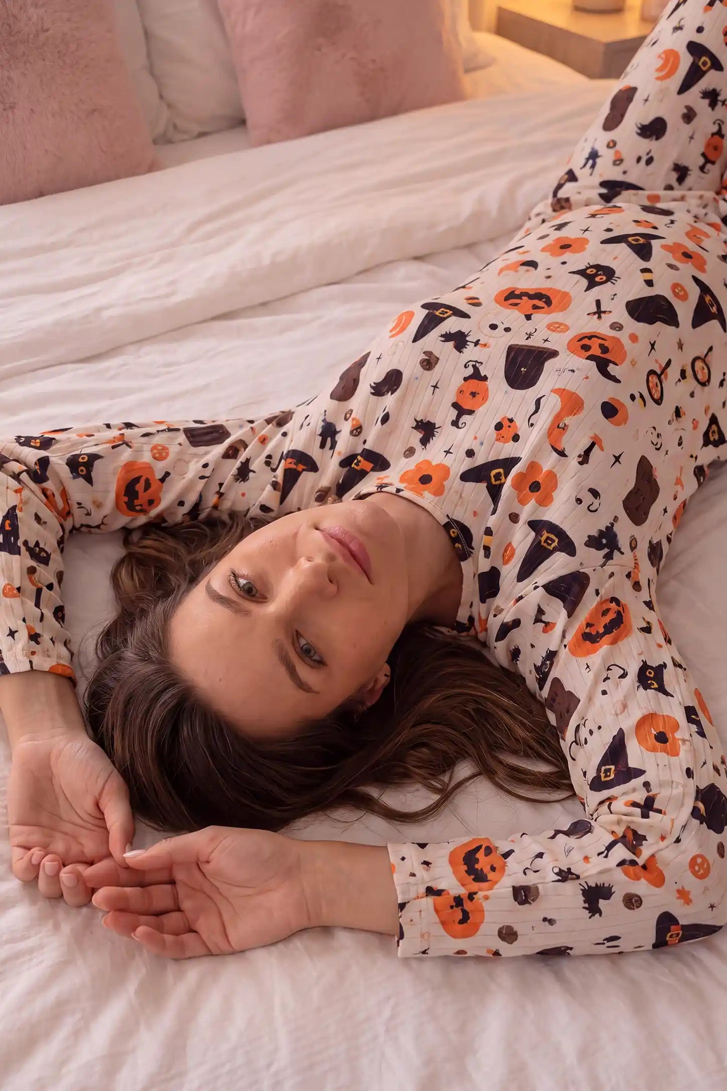 Pumpkin & Ghost Print Soft Knit Maternity Sleep Set Pumpkin & Ghost Print Soft Knit Maternity Sleep Set in Whimsical Halloween featuring cozy crew neck, soft knit material, slight stretch flexibility, and relaxed loungewear style on a pregnant model, lying down front view.