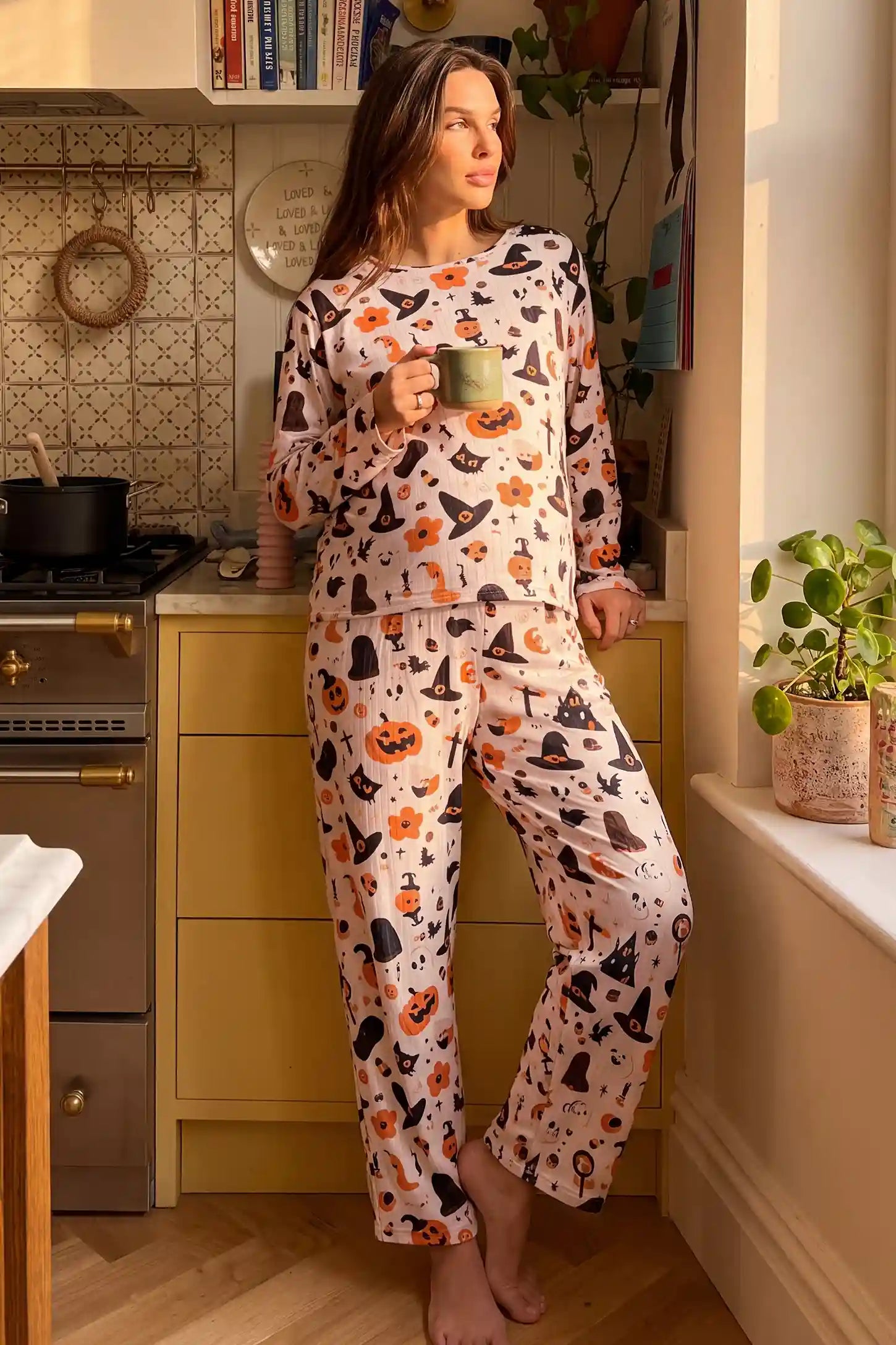Pumpkin & Ghost Print Soft Knit Maternity Sleep Set Pumpkin & Ghost Print Soft Knit Maternity Sleep Set in Whimsical Halloween featuring long sleeve top, full-length cozy pants, comfortable relaxed fit, and festive print on a pregnant model, full-body standing view.