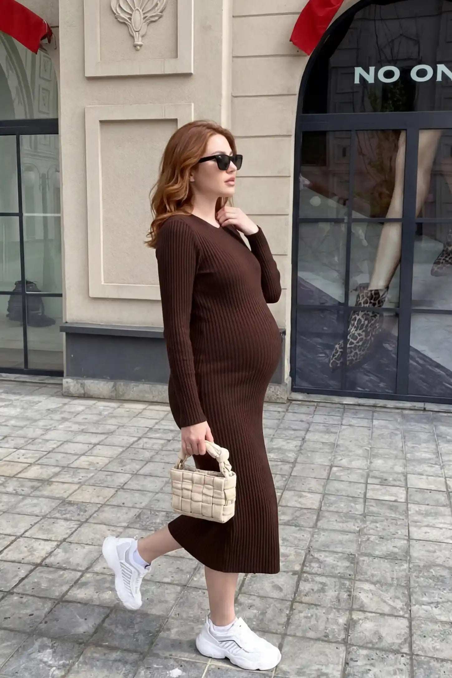 Ribbed Knit Long Sleeve Maternity Midi Dress Ribbed knit long sleeve maternity midi dress in brown with smooth stretch ribbed knit fabric, side view on pregnant model