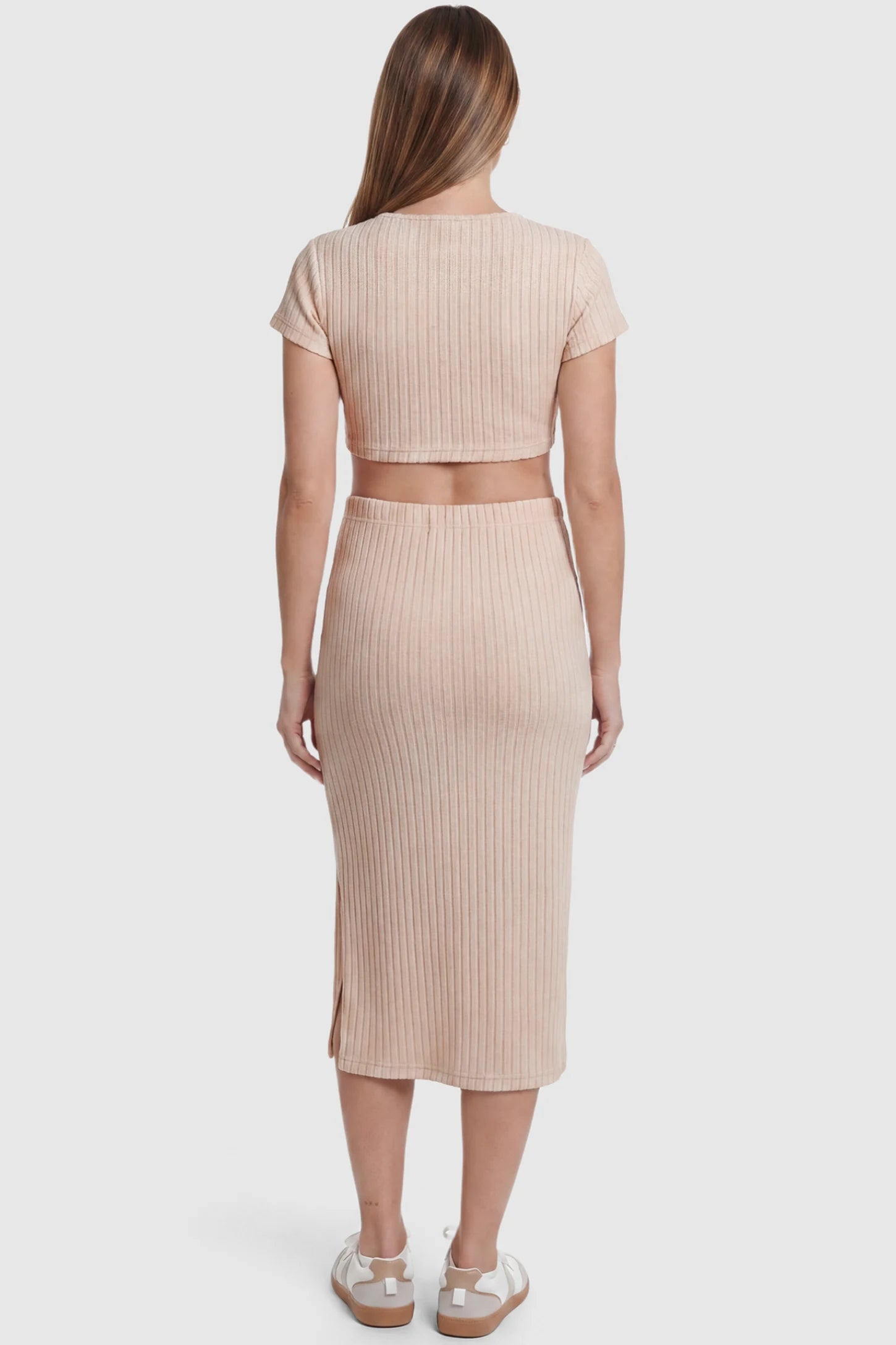 Ribbed Bodycon Crop Top & Skirt Maternity Set Ribbed Bodycon Crop Top & Skirt Maternity Set in beige featuring a fitted ribbed knit silhouette with side slit on a pregnant model back view.