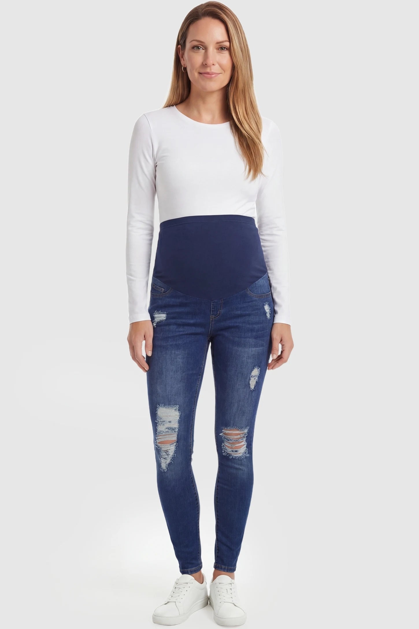 Distressed Ripped High-Waist Skinny Maternity Jeans Distressed ripped high-waist skinny maternity jeans in dark blue with ripped design, full body on postpartum model