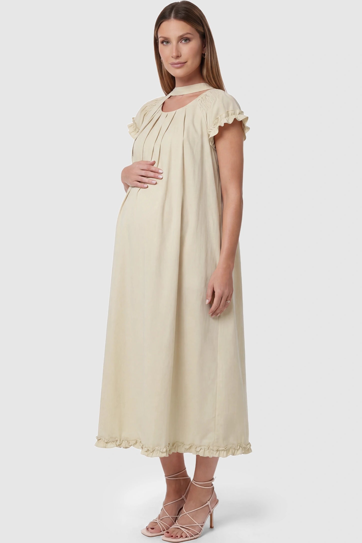 Round Neck Short Sleeve Maternity Midi Dress with Pockets Round neck short sleeve maternity midi dress with pockets in beige with shorts sleeve and tie neck detail, side view on pregnant model