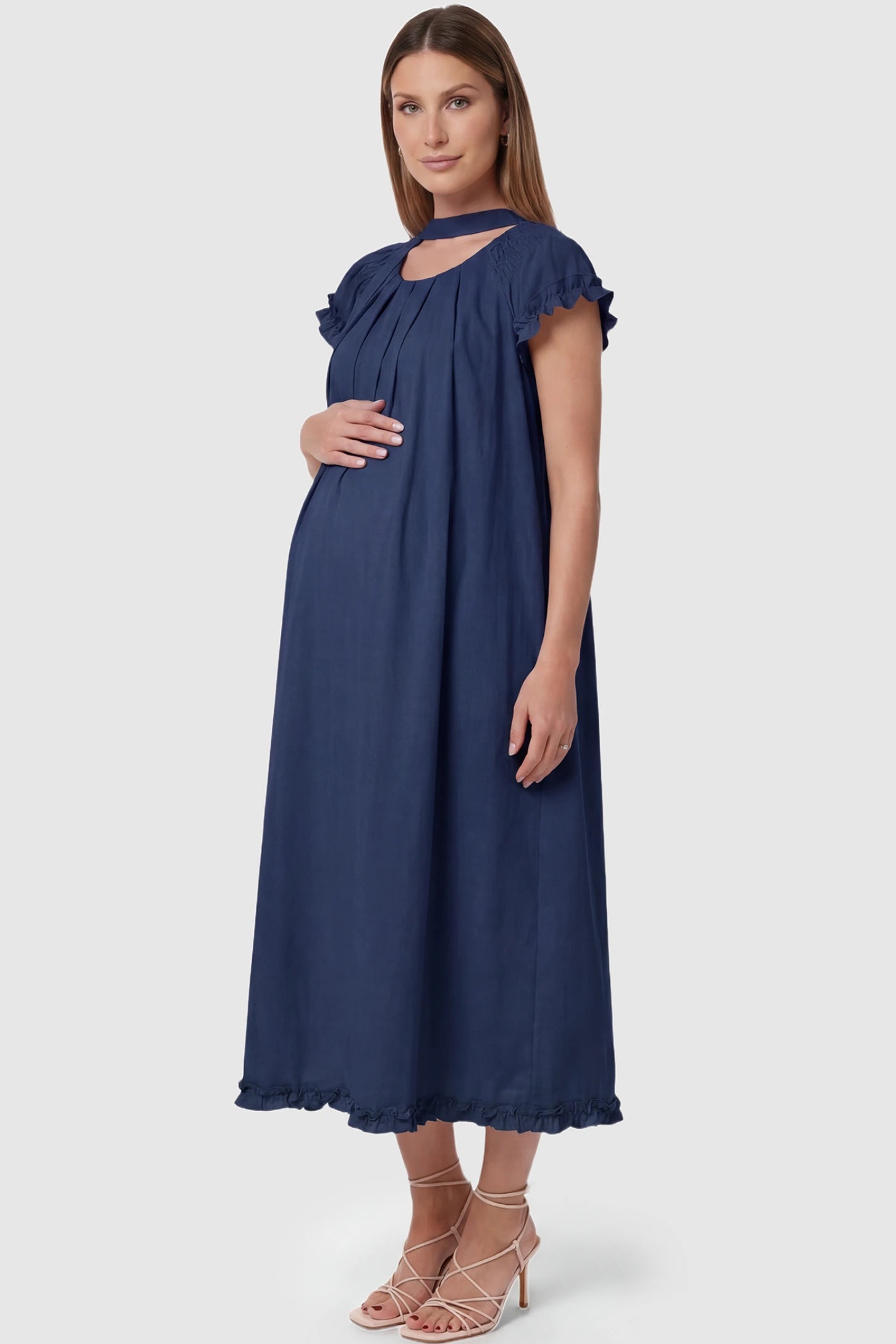 Round Neck Short Sleeve Maternity Midi Dress with Pockets Round neck short sleeve maternity midi dress with pockets in blue with shorts sleeve and tie neck detail, side view on pregnant model