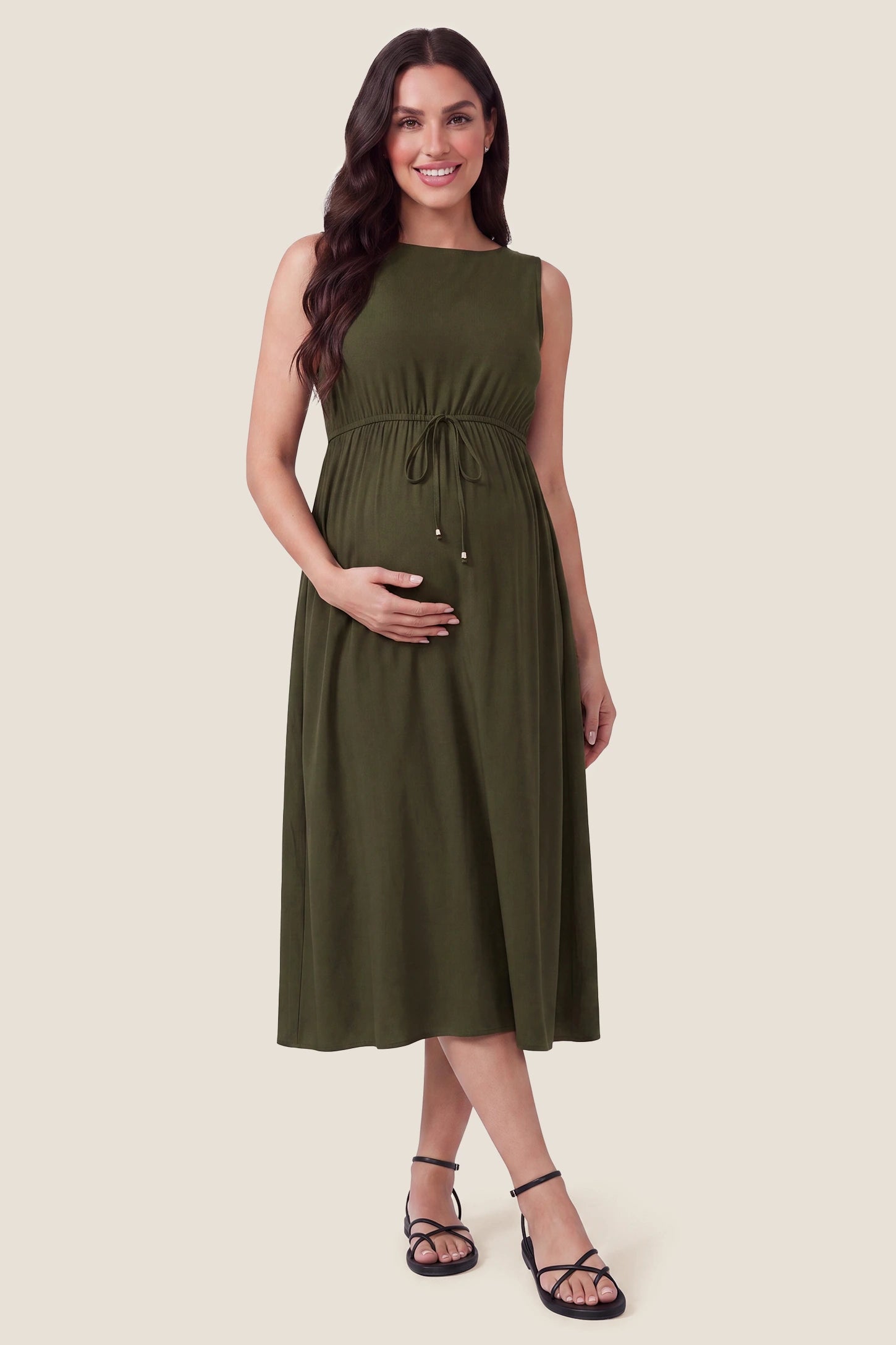 Drawstring Waist Sleeveless Full Skirt Maternity Skater Dress Drawstring Waist Sleeveless Maternity Skater Dress in Army Green featuring a flexible adjustable waist on a pregnant model.