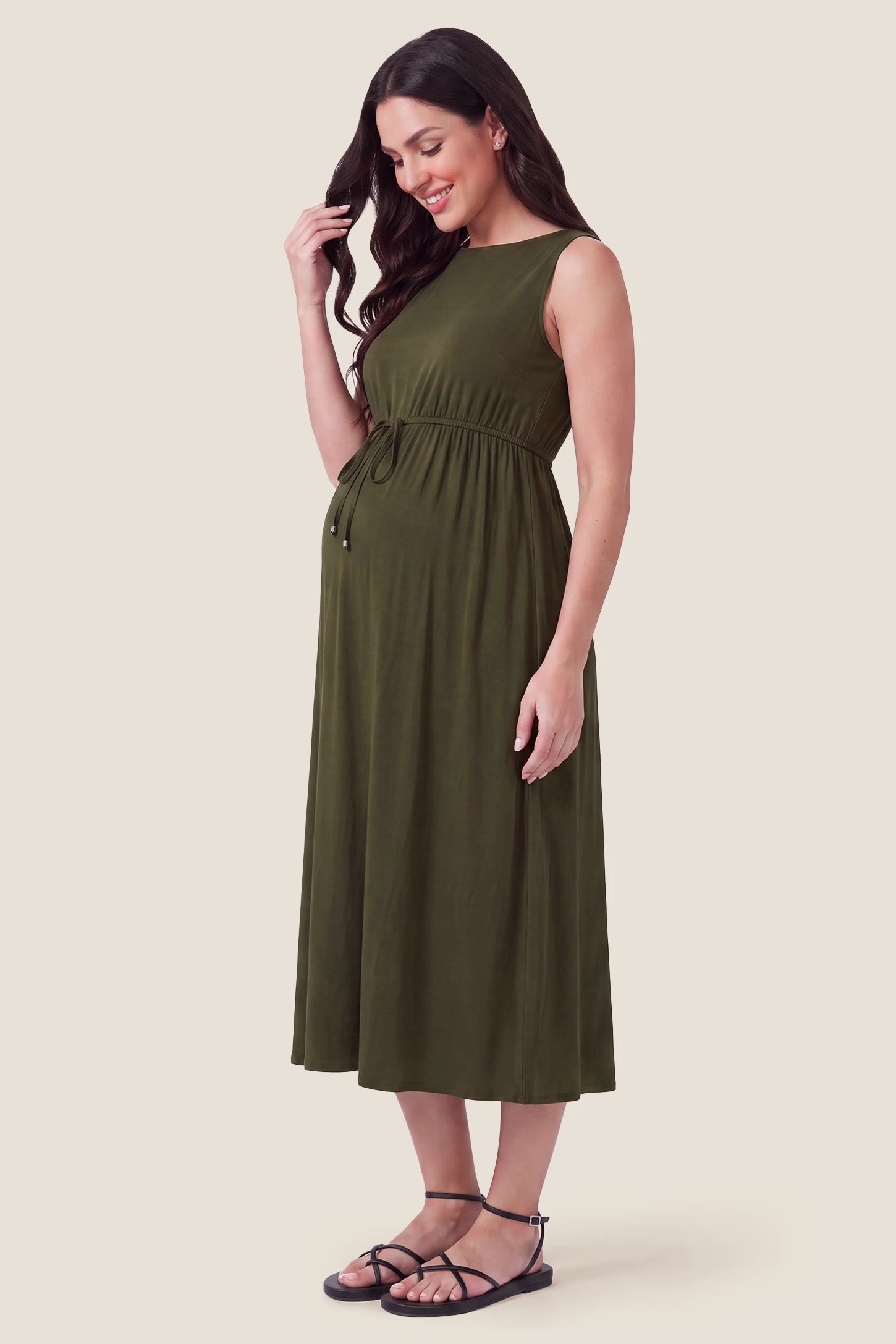 Drawstring Waist Sleeveless Full Skirt Maternity Skater Dress Drawstring Waist Sleeveless Maternity Skater Dress in Army Green featuring a side profile bump view on a pregnant model.