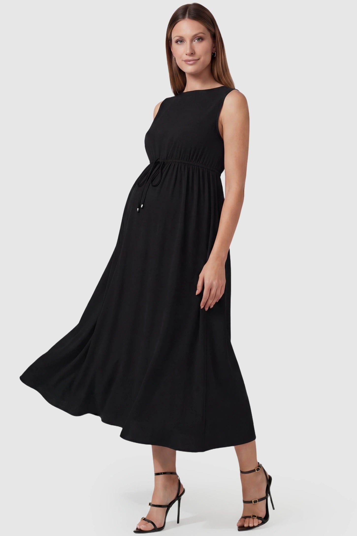 Drawstring Waist Sleeveless Full Skirt Maternity Skater Dress Drawstring Waist Sleeveless Maternity Skater Dress in Black featuring a side profile bump view on a pregnant model.