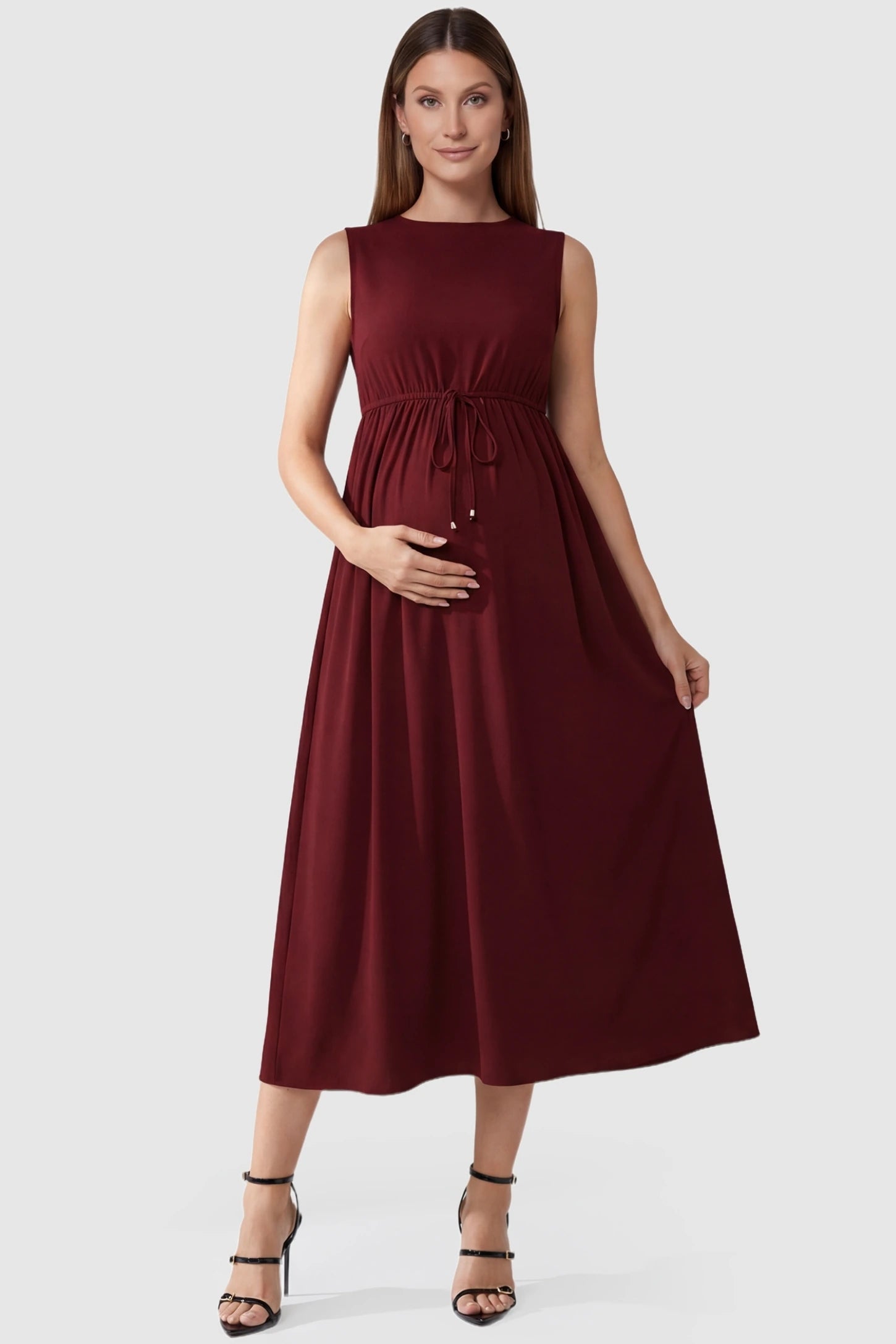 Drawstring Waist Sleeveless Maternity Skater Dress in Burgundy featuring a flexible adjustable waist on a pregnant model.