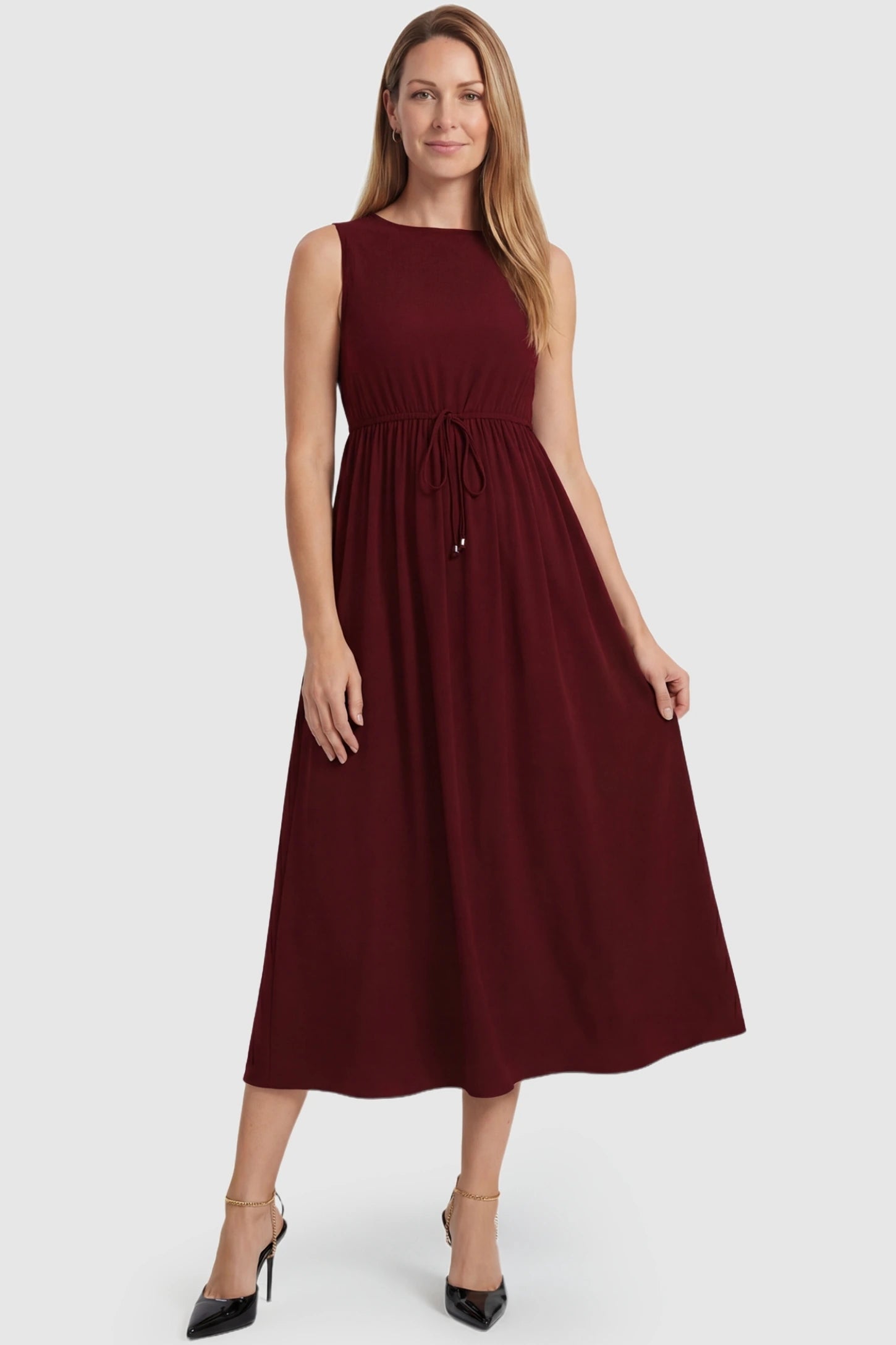 Drawstring Waist Sleeveless Full Skirt Maternity Skater Dress Drawstring Waist Sleeveless Maternity Skater Dress in Burgundy featuring a cinched drawstring on a postpartum model.