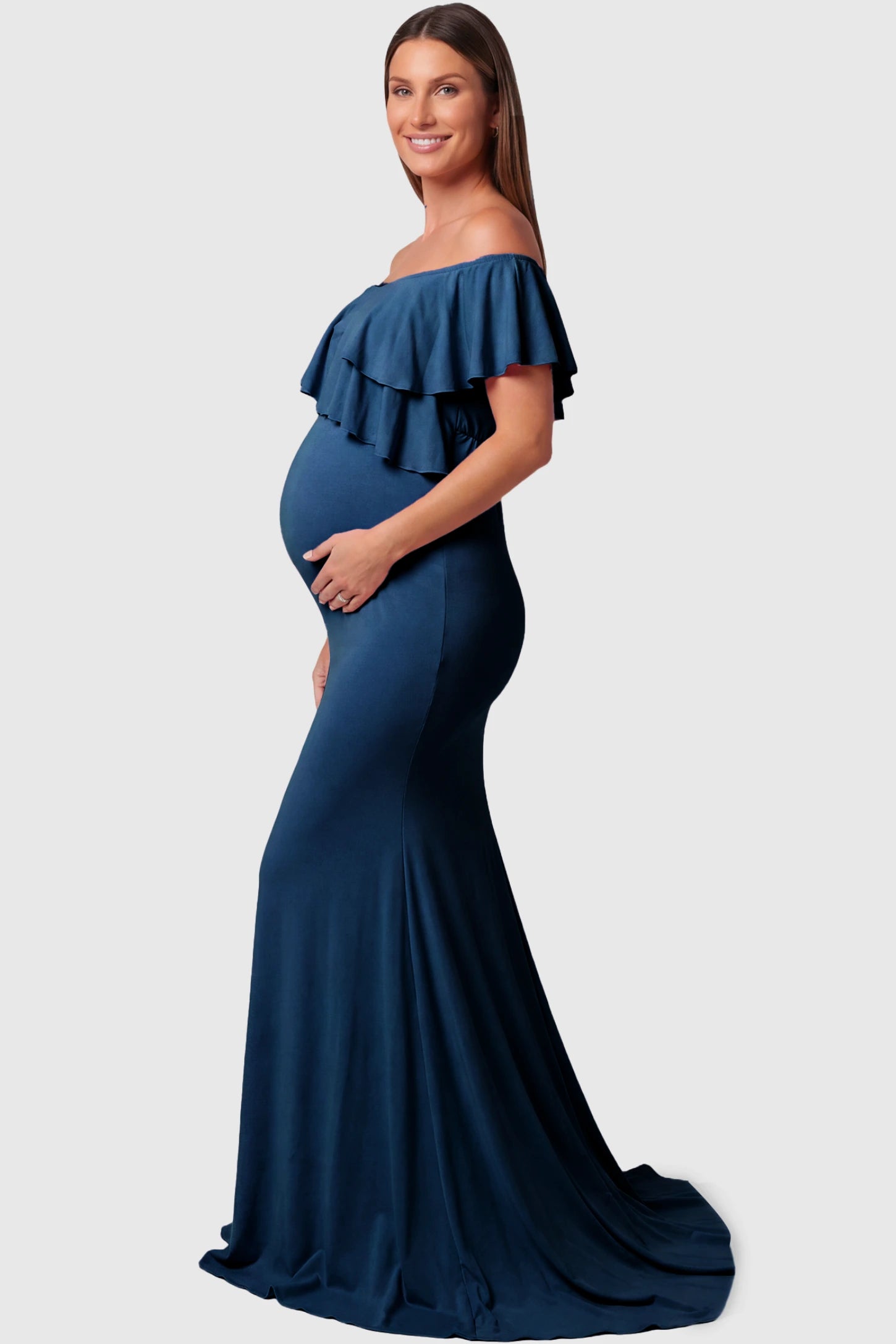 Off-Shoulder Mermaid Maternity Gown Off-Shoulder Mermaid Maternity Gown in light denim blue featuring ruffle overlay, flounce neckline, and sweep train on pregnant model.