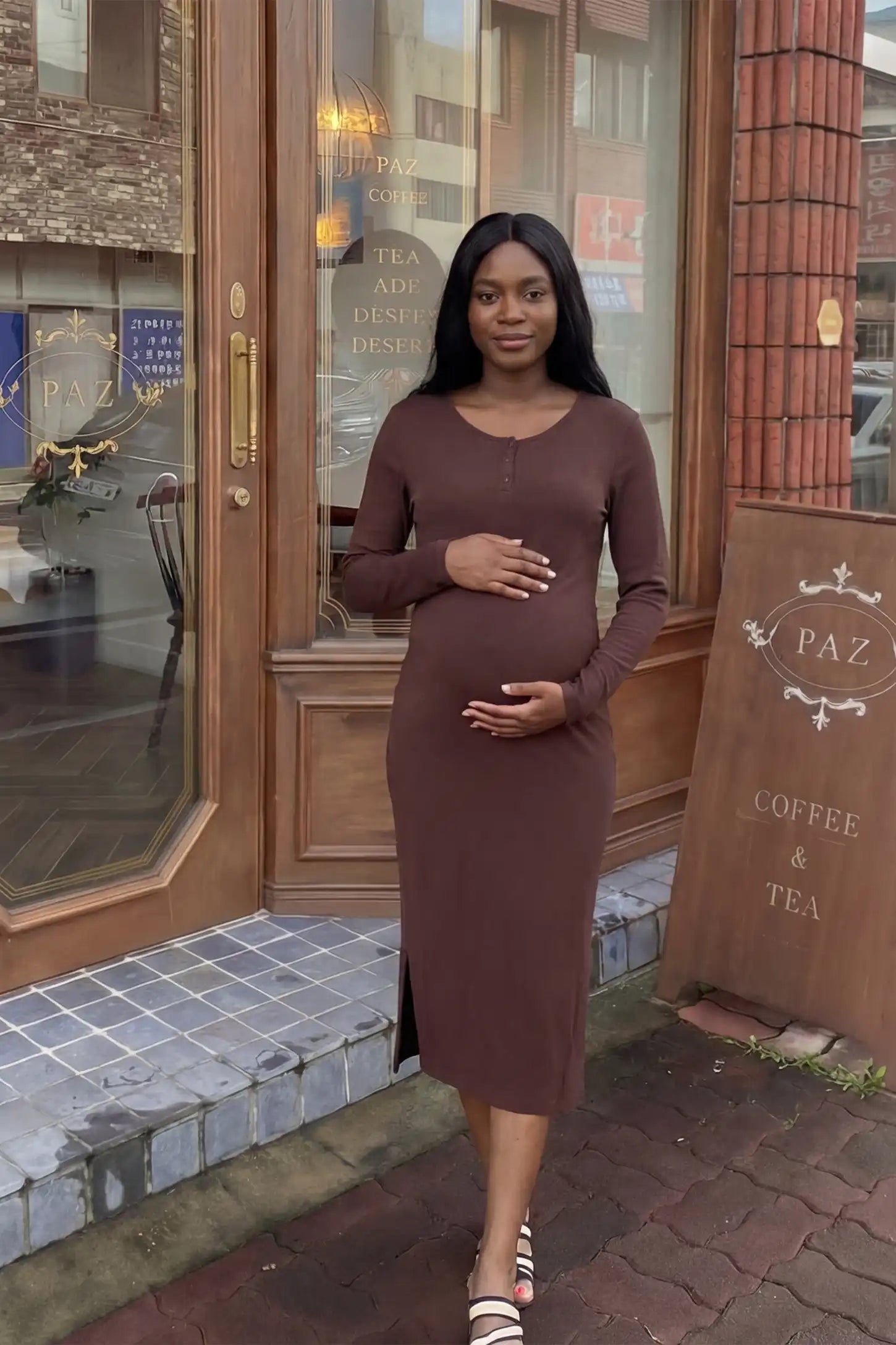 Scoop-neck button chest long-sleeve midi maternity dress in dark brown with modern feminine silhouette, on editorial lifestyle model