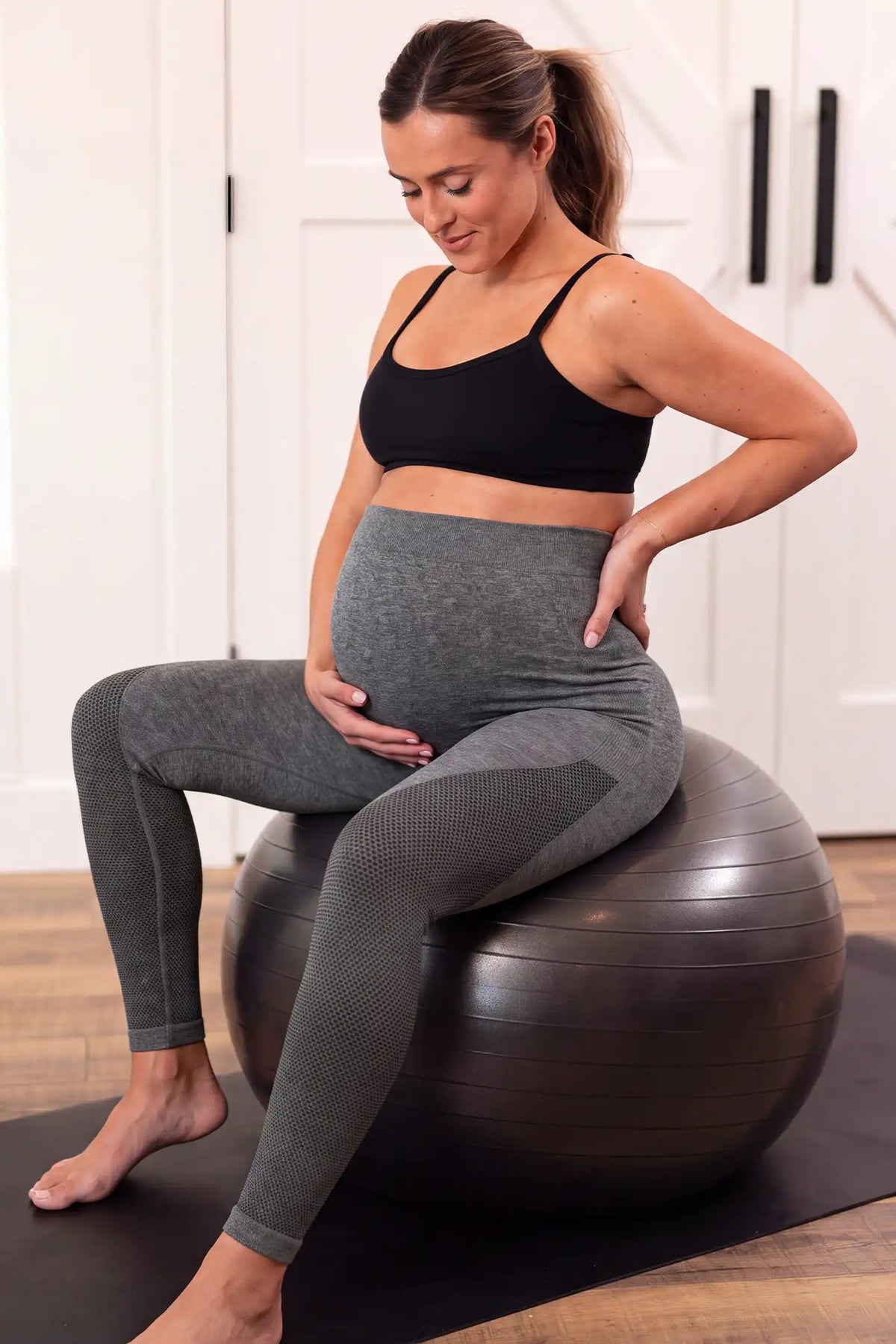 Seamless Over-the-Bump Maternity Leggings Seamless Over-the-Bump Maternity Leggings in Grey featuring gentle lumbar pressure relief, flexible movement support, and comfortable activewear style on a pregnant model, seated fitness lifestyle view.