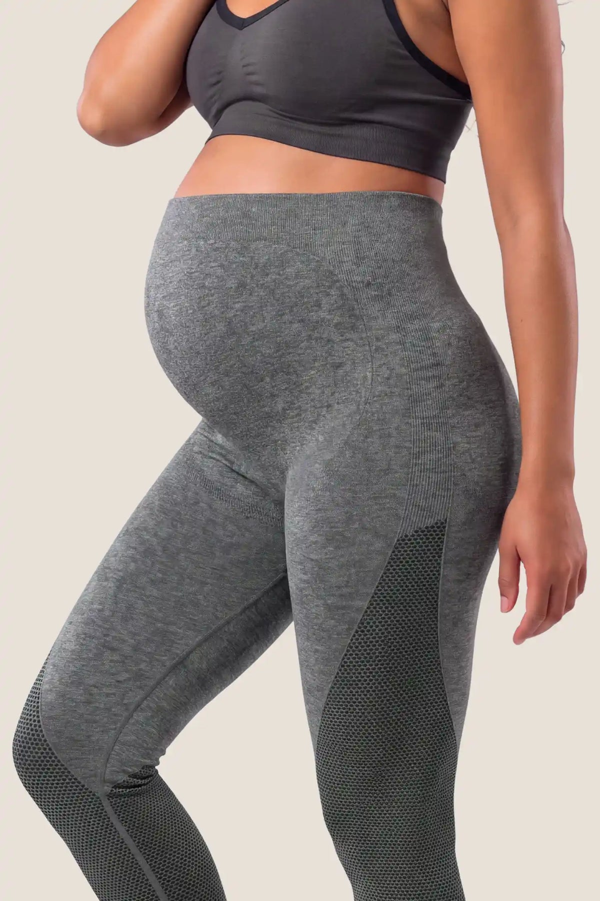 Seamless Over-the-Bump Maternity Leggings Seamless Over-the-Bump Maternity Leggings in Grey featuring 360° over-the-bump belly support, breathable honeycomb knit panels, and flexible movement support on a pregnant model, bump close-up view.