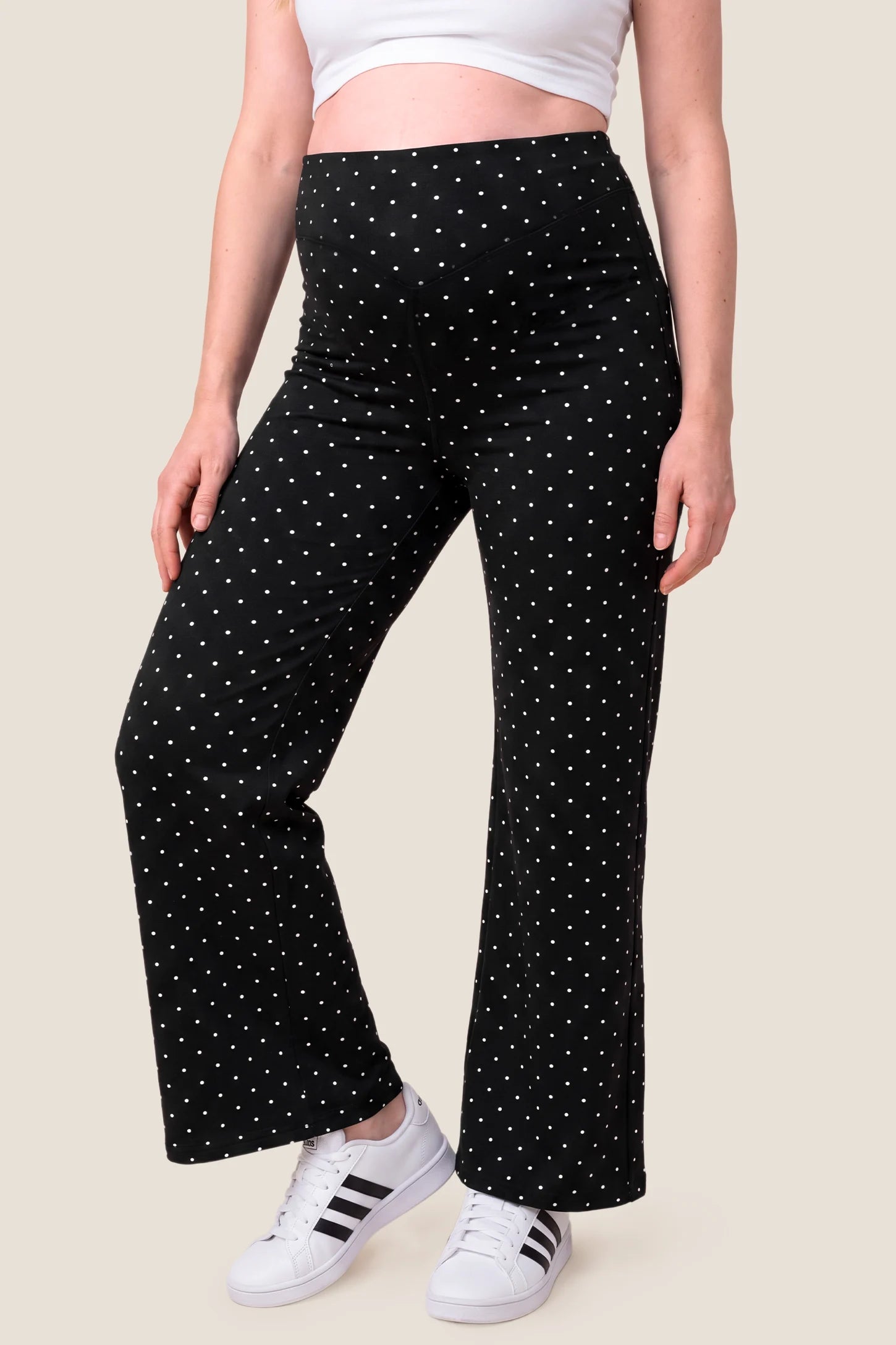 Seamless Polka Dot Maternity Flare Yoga Pants Seamless Polka Dot Maternity Flare Yoga Pants in Black Polka Dot featuring classic polka dot print, wide-leg flare cut, and soft stretchy comfort on a pregnant model, front view.