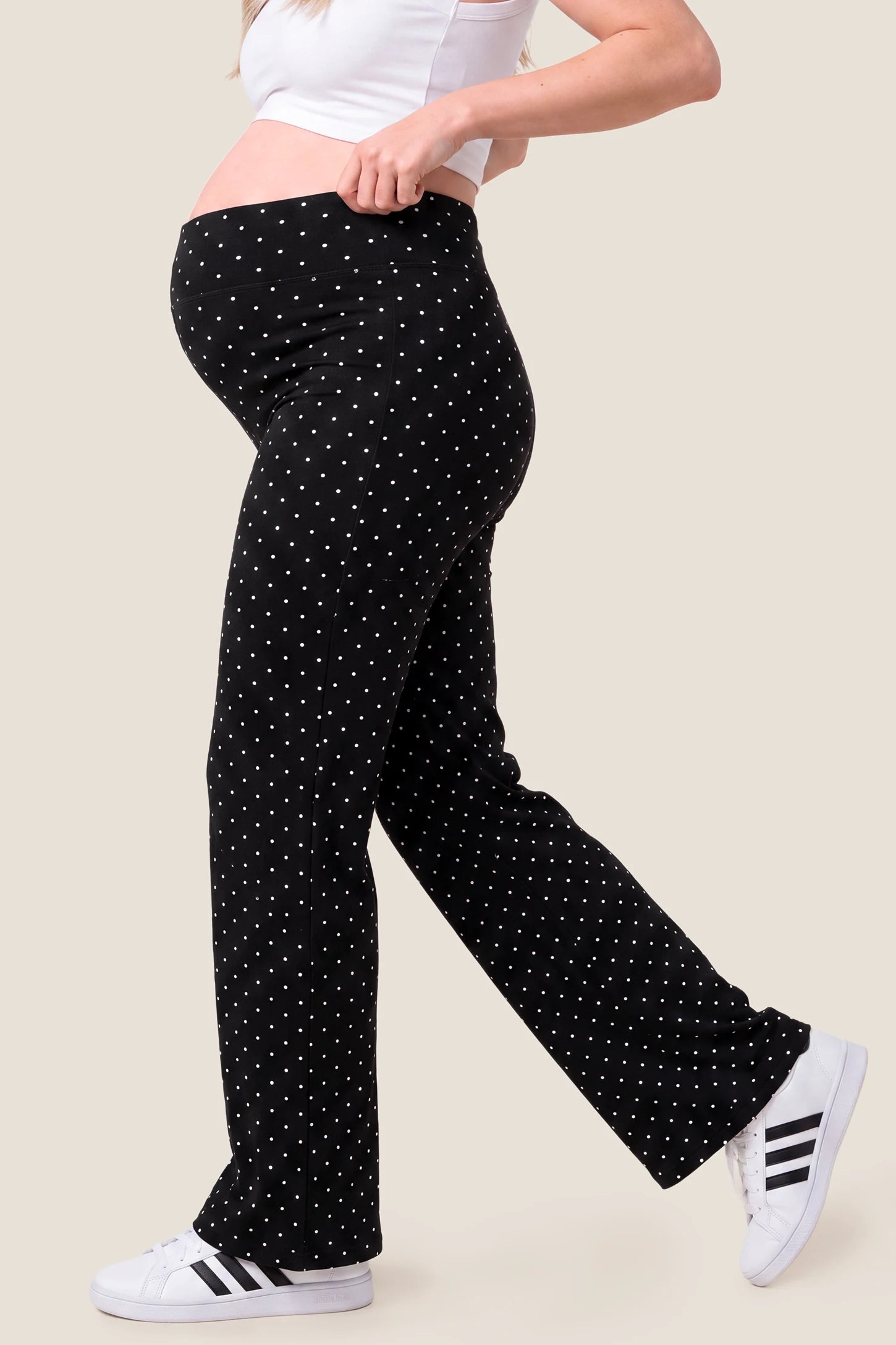 Seamless Polka Dot Maternity Flare Yoga Pants Seamless Polka Dot Maternity Flare Yoga Pants in Black Polka Dot featuring accommodating belly stretch design, wide-leg flare cut, and gentle bump support on a pregnant model, side profile view.