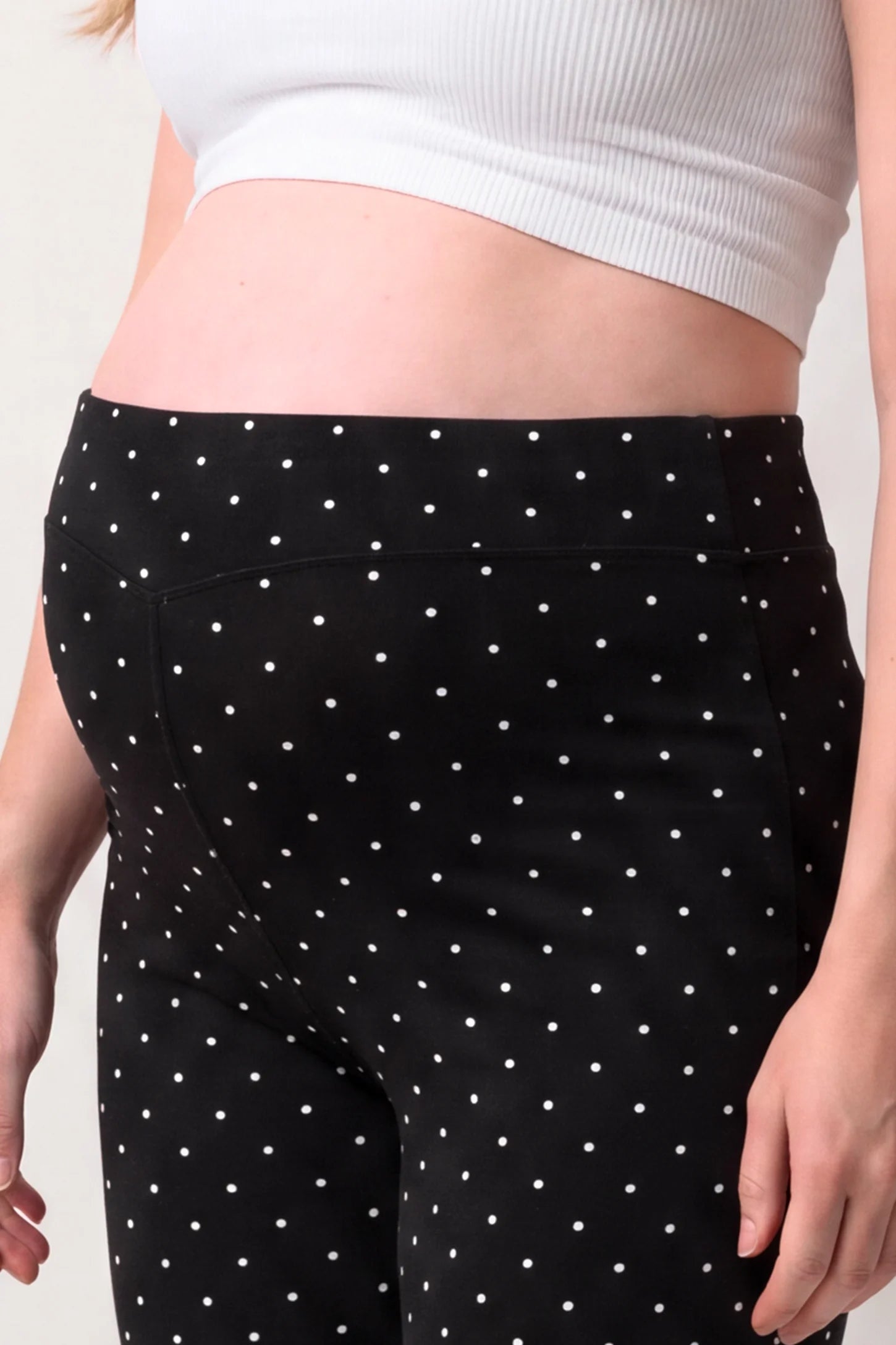 Seamless Polka Dot Maternity Flare Yoga Pants Seamless Polka Dot Maternity Flare Yoga Pants in Black Polka Dot featuring accommodating belly stretch design, polka dot pattern, and soft moisture-wicking fabric, bump close-up view.