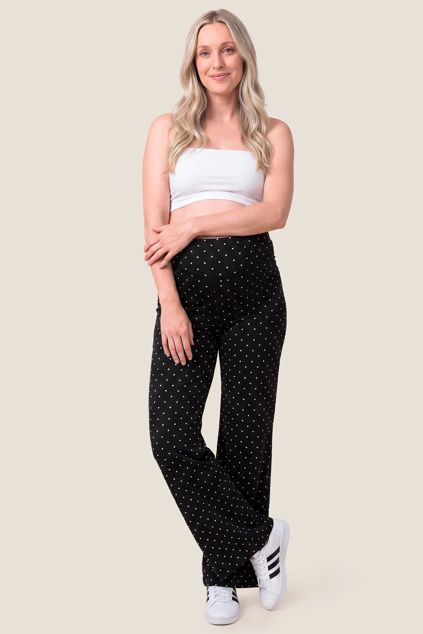 Seamless Polka Dot Maternity Flare Yoga Pants Seamless Polka Dot Maternity Flare Yoga Pants in Black Polka Dot featuring full panel belly support, flexible stretch fabric, and relaxed silhouette for workouts and everyday wear on a pregnant model, full-body front view.