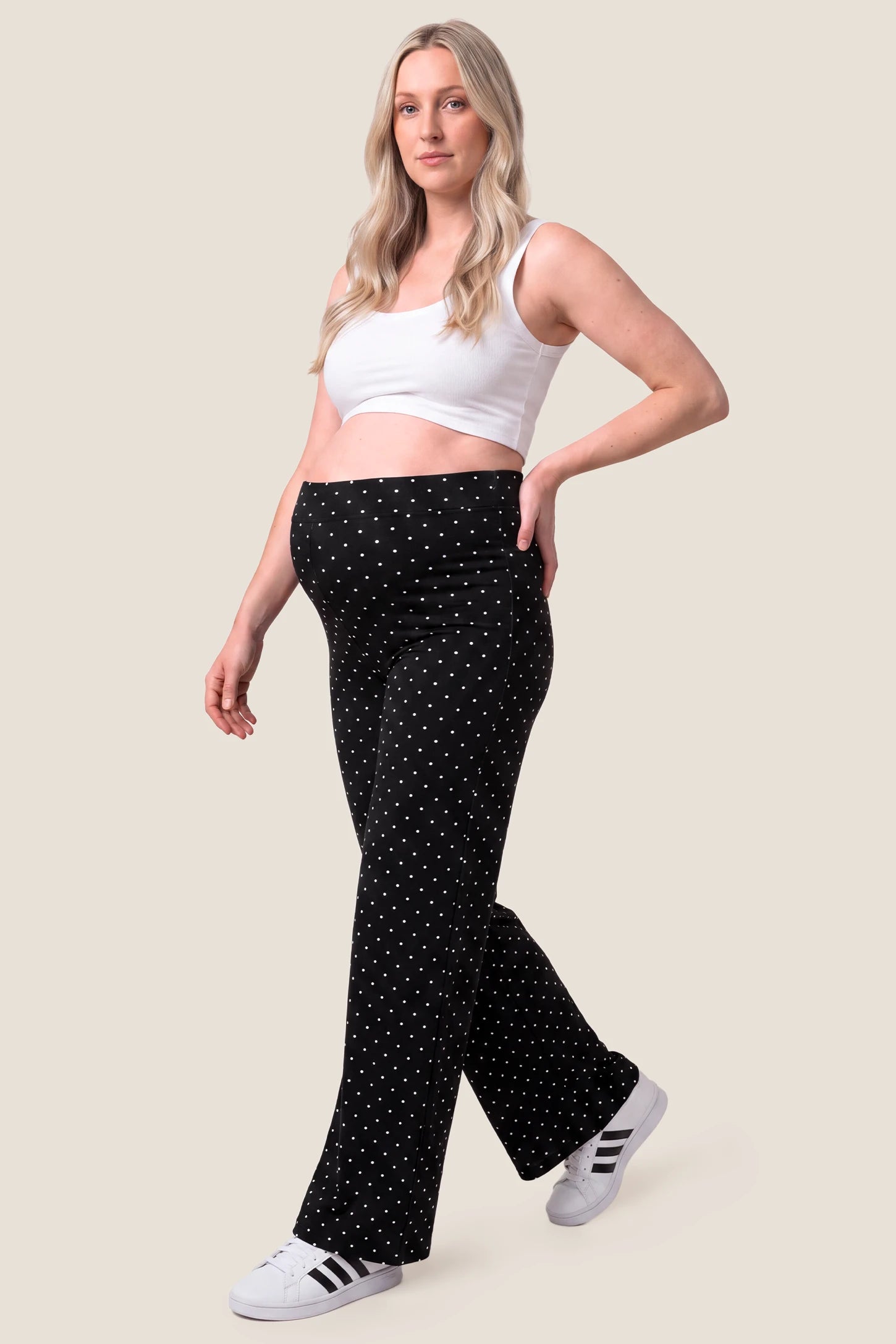 Seamless Polka Dot Maternity Flare Yoga Pants Seamless Polka Dot Maternity Flare Yoga Pants in Black Polka Dot featuring lightweight moisture-wicking material, four-way stretch flexibility, and stylish flare leg design on a pregnant model, full-body walking view.