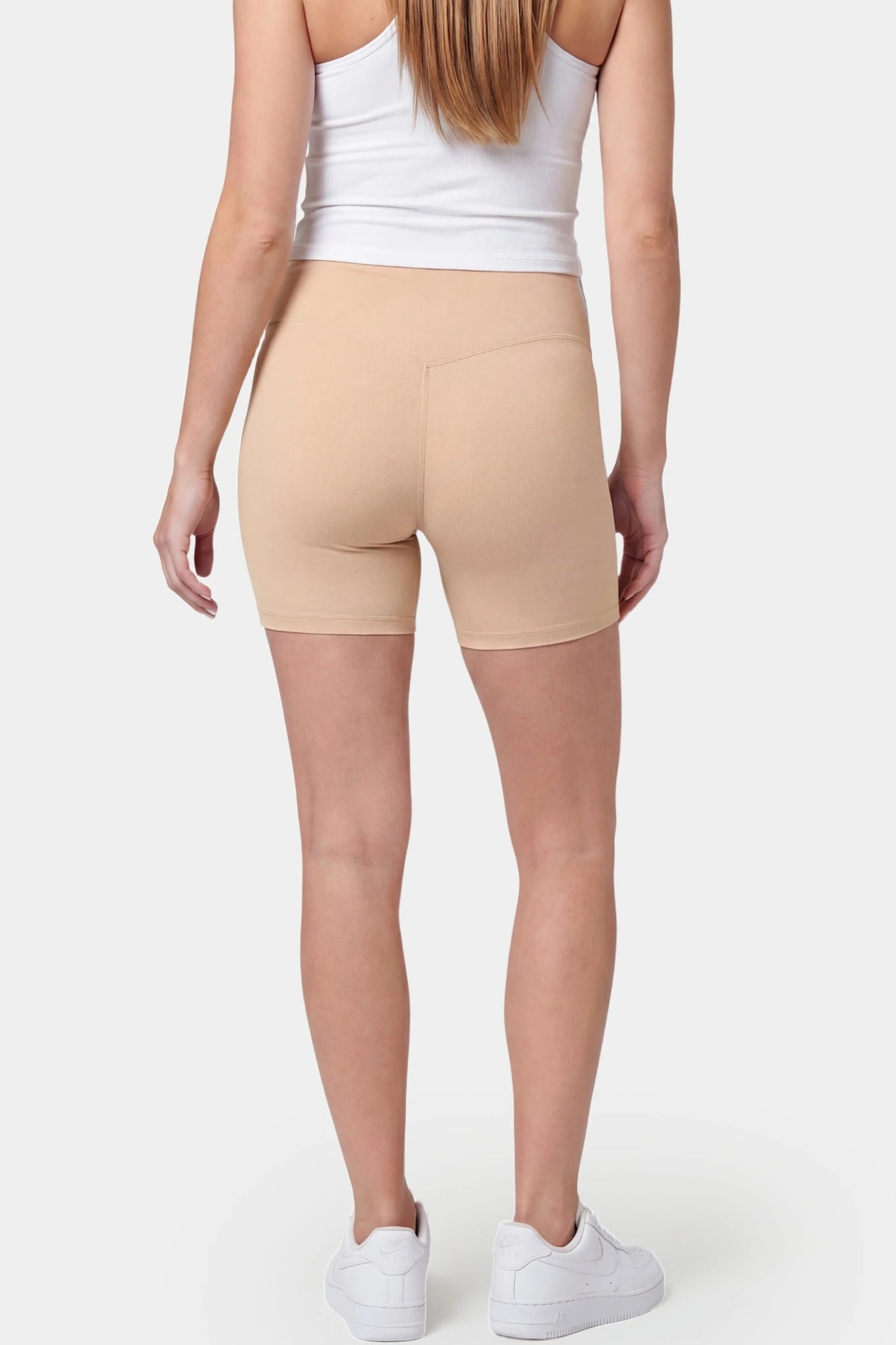 Seamless Belly Support Mid-Thigh Shaping Maternity Shorts Seamless belly support mid-thigh shaping maternity shorts in beige with smoothing rear design, back view on pregnant model