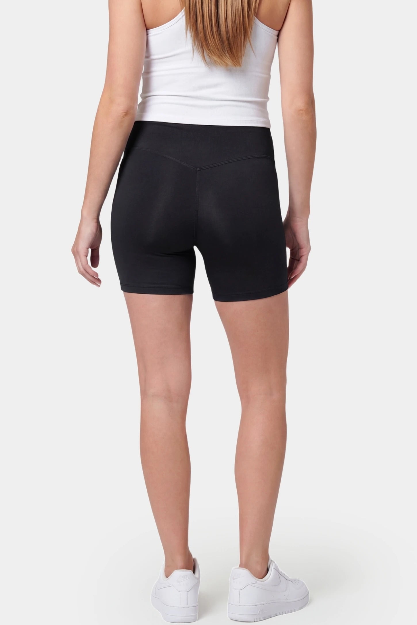 Seamless Belly Support Mid-Thigh Shaping Maternity Shorts Seamless belly support mid-thigh shaping maternity shorts in black with smoothing rear design, back view on pregnant model