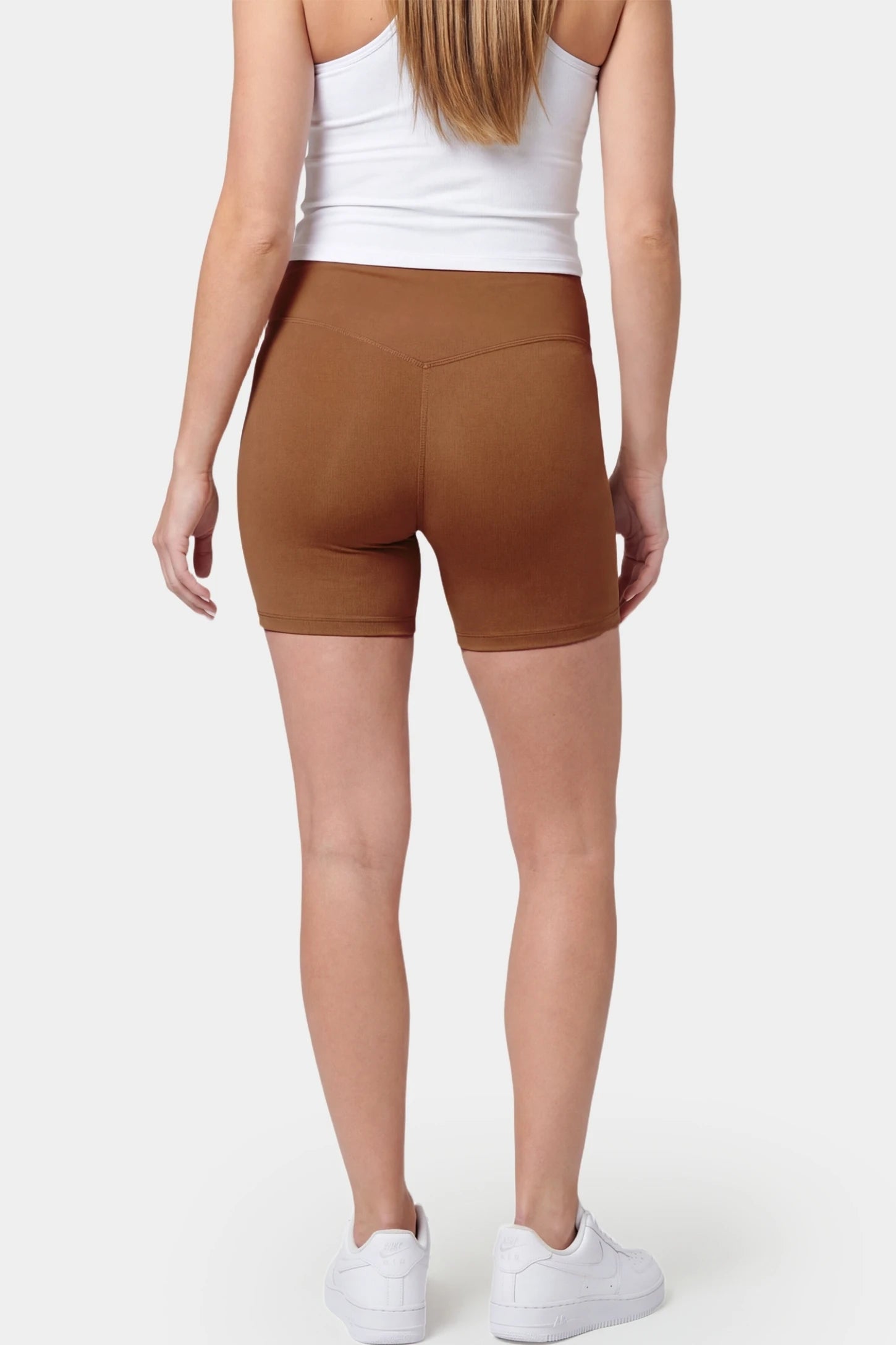 Seamless Belly Support Mid-Thigh Shaping Maternity Shorts Seamless belly support mid-thigh shaping maternity shorts in brown with smoothing rear design, back view on pregnant model