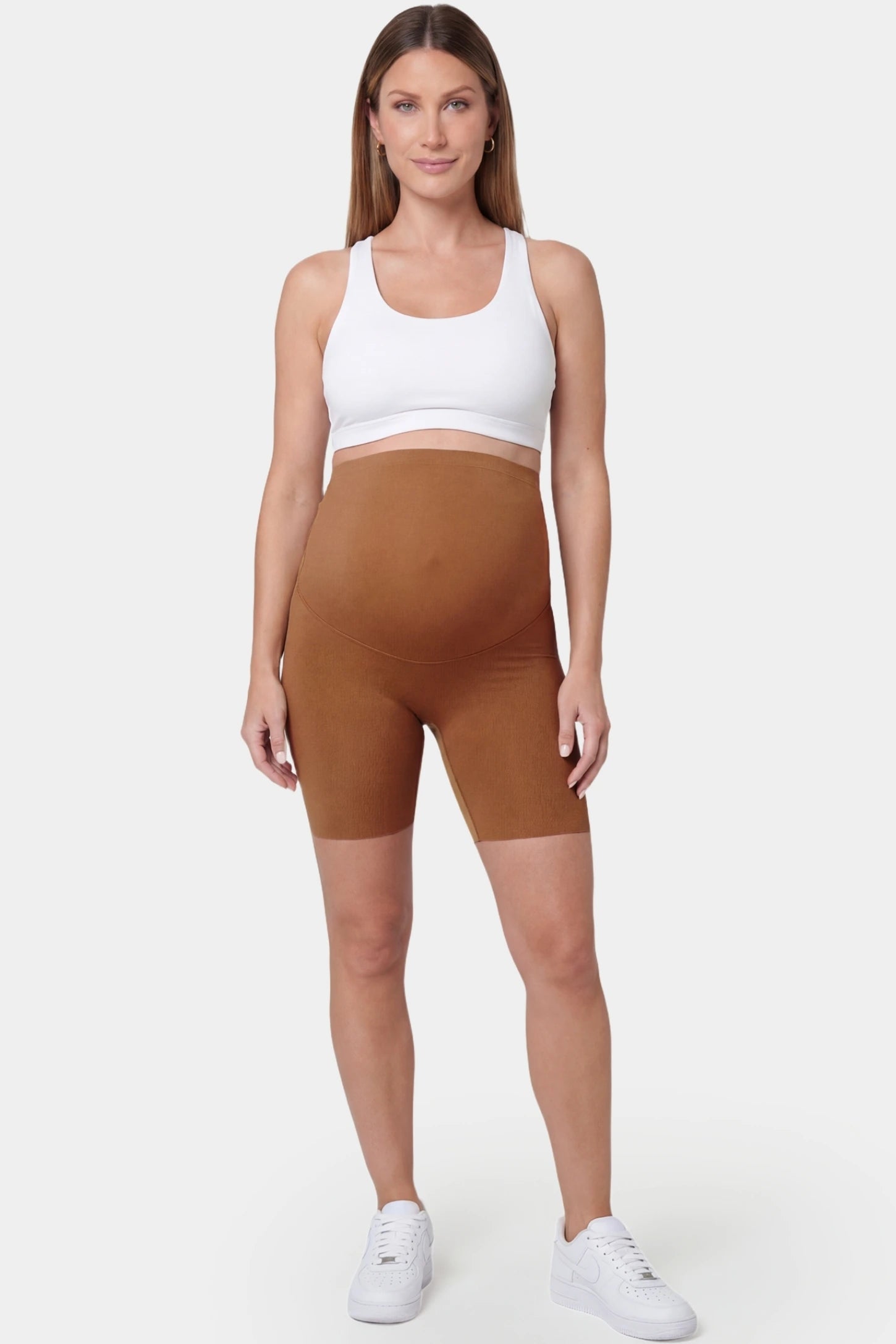 Seamless Belly Support Mid-Thigh Shaping Maternity Shorts Seamless belly support mid-thigh shaping maternity shorts in brown with sculpting fit, full body on pregnant model