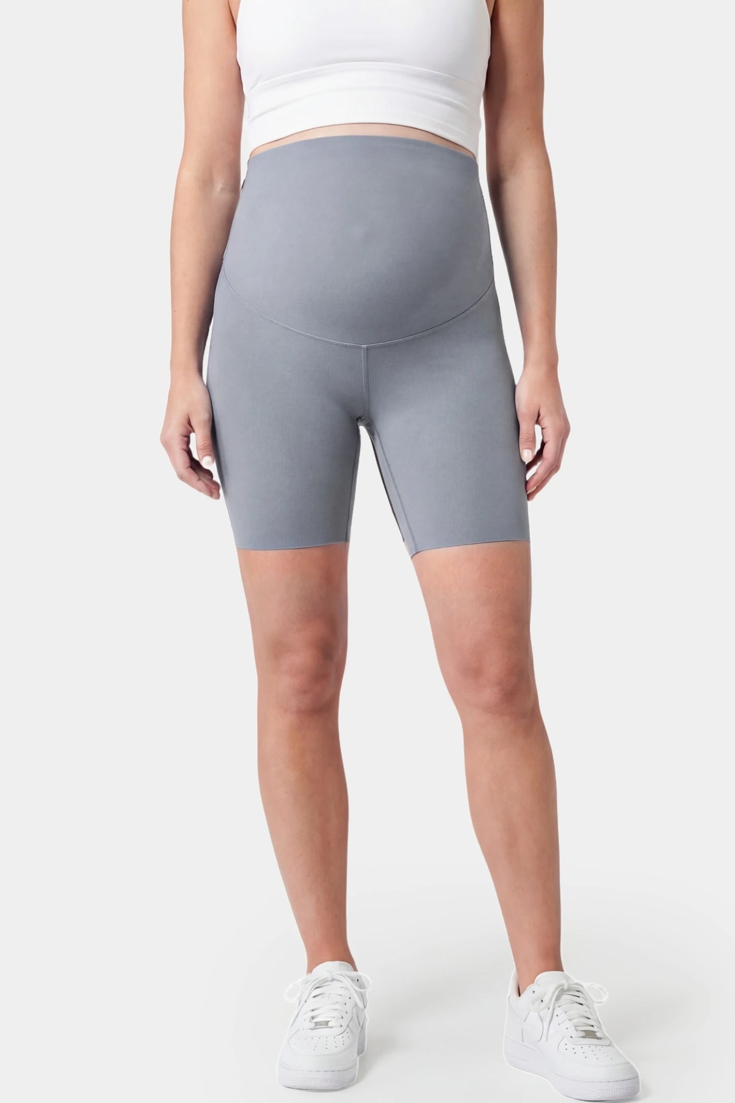 Seamless belly support mid-thigh shaping maternity shorts in gray with high-waist support, front view on pregnant model