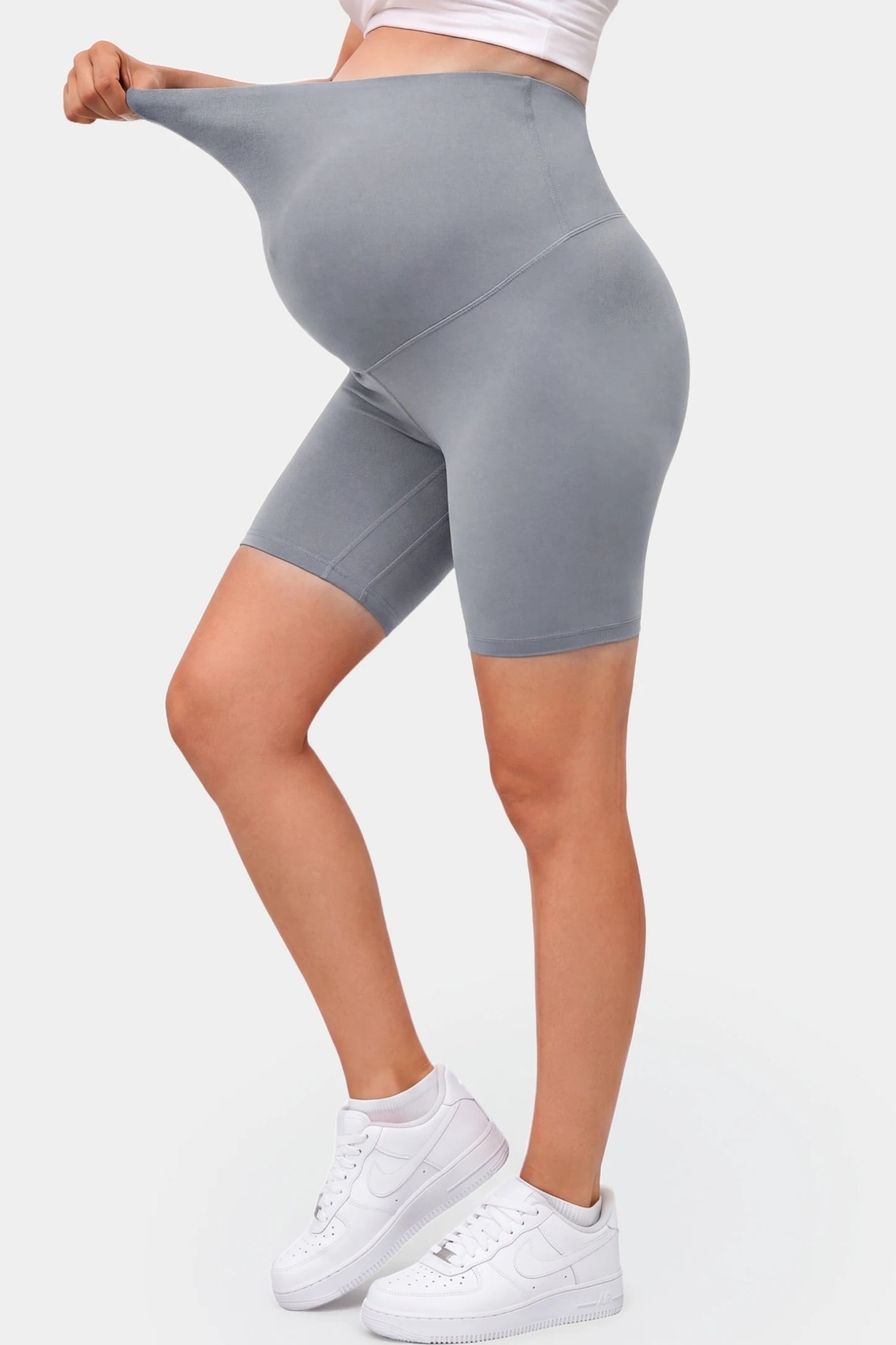 Seamless Belly Support Mid-Thigh Shaping Maternity Shorts Seamless belly support mid-thigh shaping maternity shorts in gray with flexible compression, side view on pregnant model