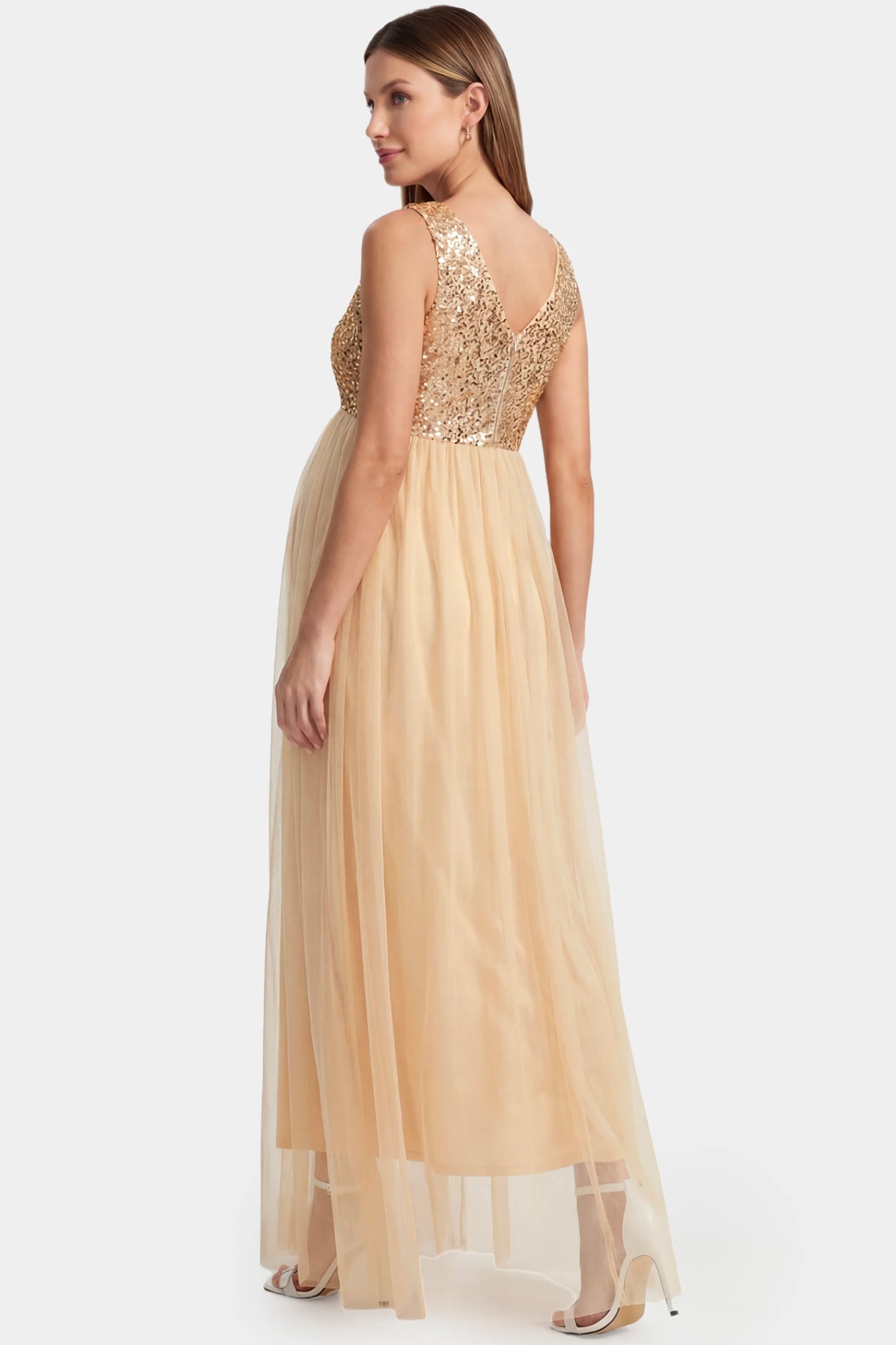 Sequin Bodice Sleeveless Maxi Maternity Dress Sequin bodice sleeveless maxi maternity dress in gold featuring mesh skirt shown in back view on a pregnant model