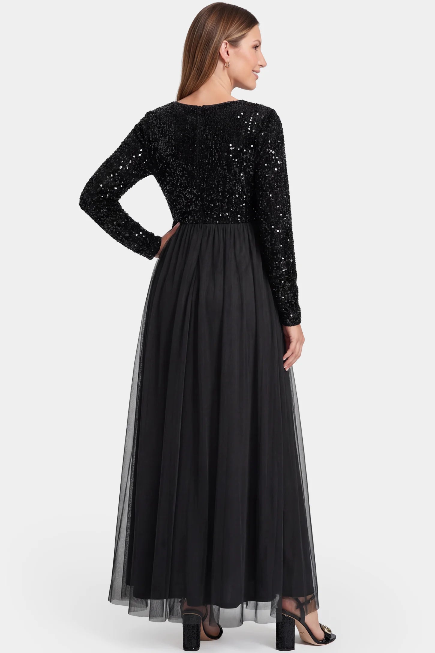 Sequined Mesh Long-Sleeve Maxi Maternity Gown Sequined mesh long sleeve maxi maternity gown in black featuring flowing mesh skirt in full body back view on a pregnant model