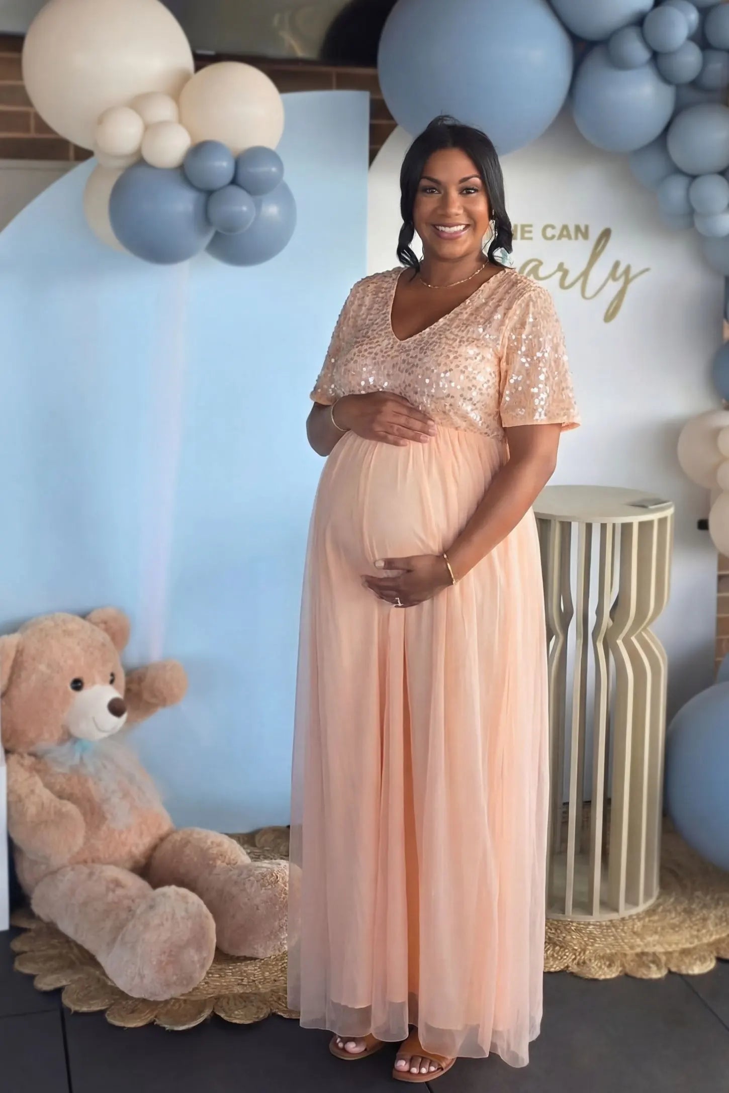 Sequin Ruffle Sleeve Maternity Photoshoot Dress in Pink featuring a flowy tulle skirt on a pregnant model, side view.