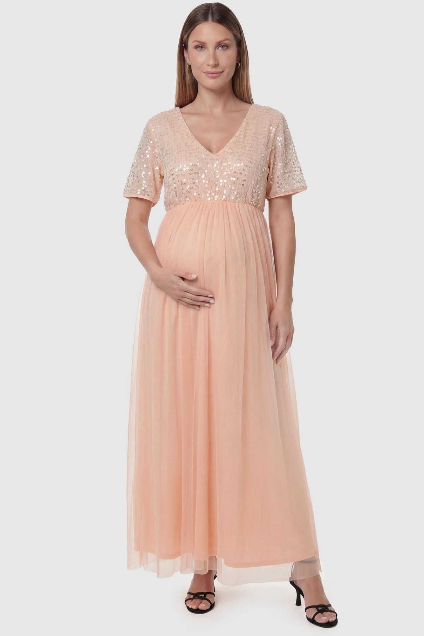 Sequin Ruffle Sleeve Maternity Photoshoot Dress in Pink featuring a sparkly bodice on a pregnant model, front view.