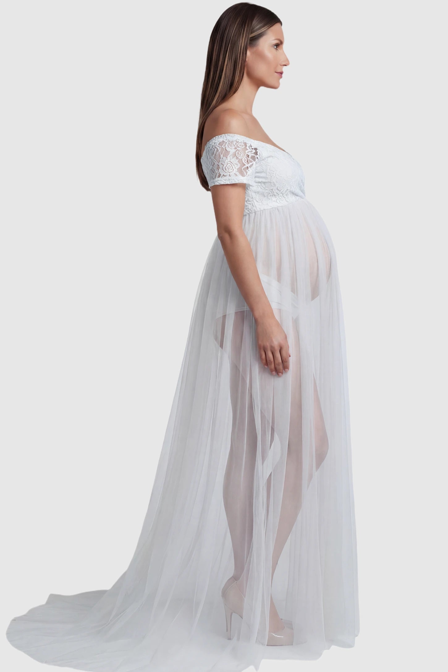 Lace Sheer Overlay Off-Shoulder Maternity Photoshoot Gown Lace Sheer Overlay Off Shoulder Maternity Photoshoot Gown in white featuring off shoulder design and flowing sheer skirt on a pregnant model.