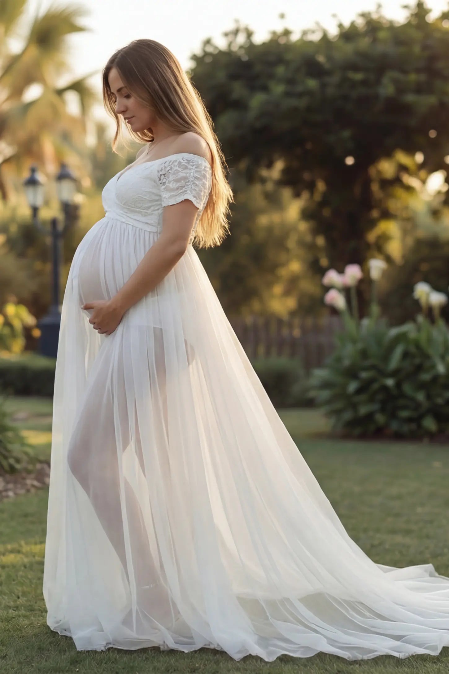 Lace Sheer Overlay Off-Shoulder Maternity Photoshoot Gown Lace Sheer Overlay Off Shoulder Maternity Photoshoot Gown in white featuring sweetheart neckline and flowing sheer skirt on a pregnant model.