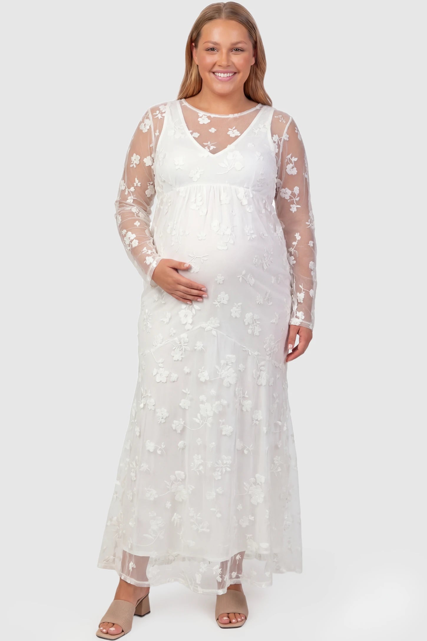 Lace Long Sheer Sleeve Bridal Maternity Gown Lace Long Sheer Sleeve Bridal Maternity Gown in white featuring floral embroidery and long sheer sleeves on a plus size pregnant model front view
