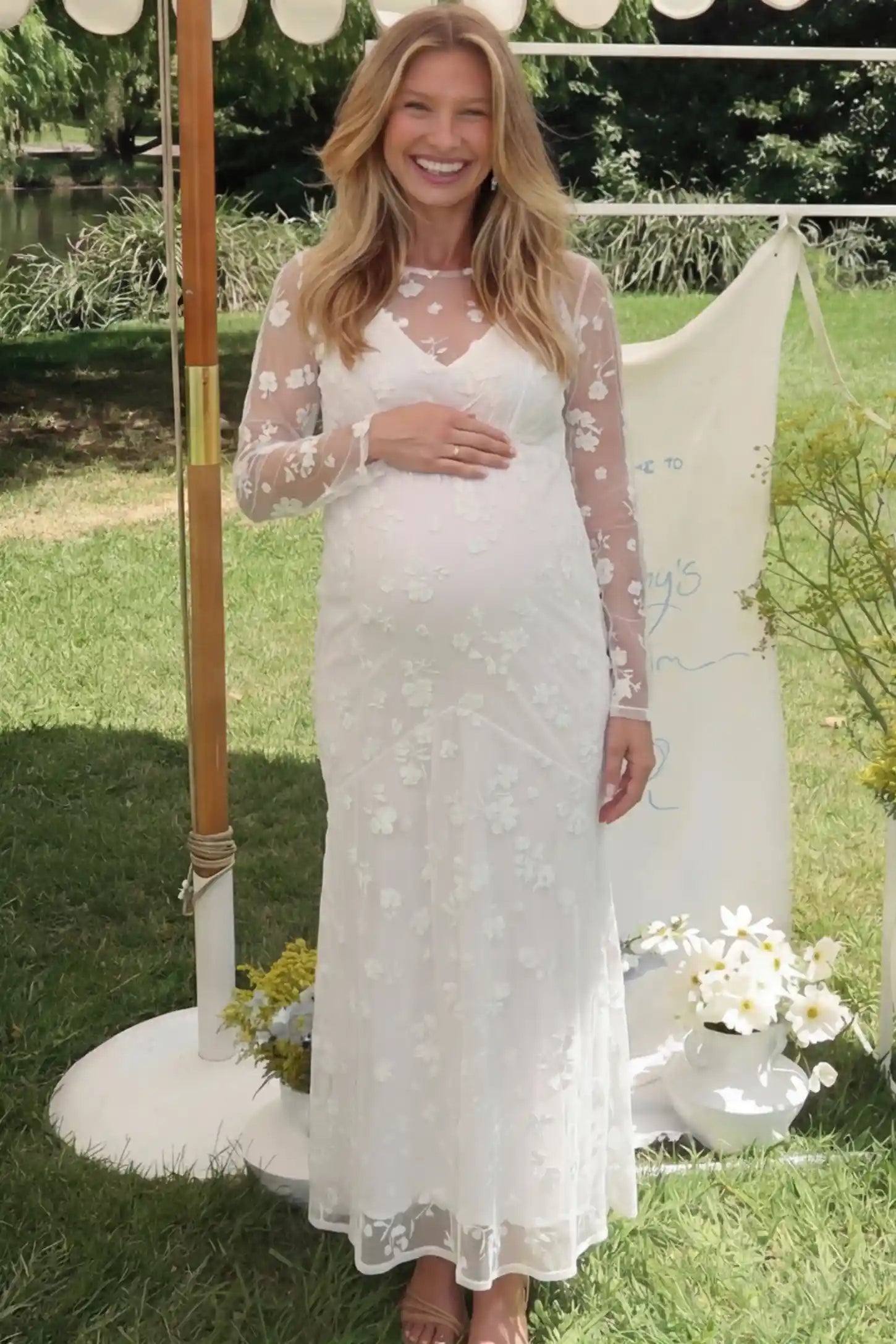 Lace Long Sheer Sleeve Bridal Maternity Gown Lace Long Sheer Sleeve Bridal Maternity Gown in white featuring floral embroidery and long sheer sleeves on a pregnant woman front view