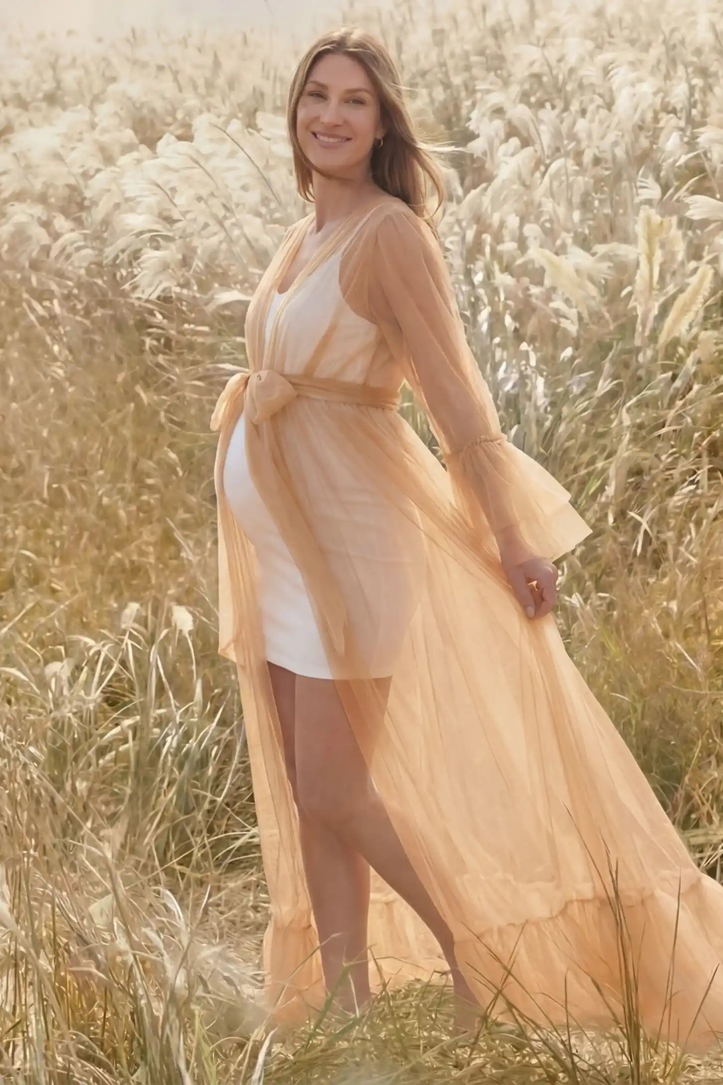 Sheer Tulle Deep V-Neck Tiered Maternity Maxi Gown Sheer tulle deep V-neck tiered maternity maxi gown in Camel with bump-enhancing layered tulle design, side view on pregnant model