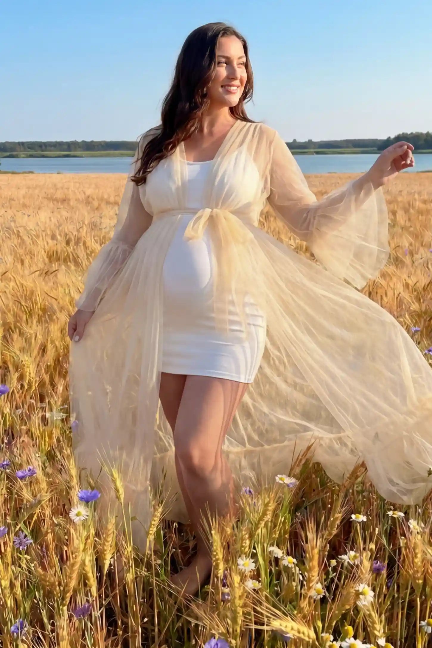 Sheer Tulle Deep V-Neck Tiered Maternity Maxi Gown Sheer tulle deep V-neck tiered maternity maxi gown in Ivory with dramatic ethereal silhouette, side view on plus-size model