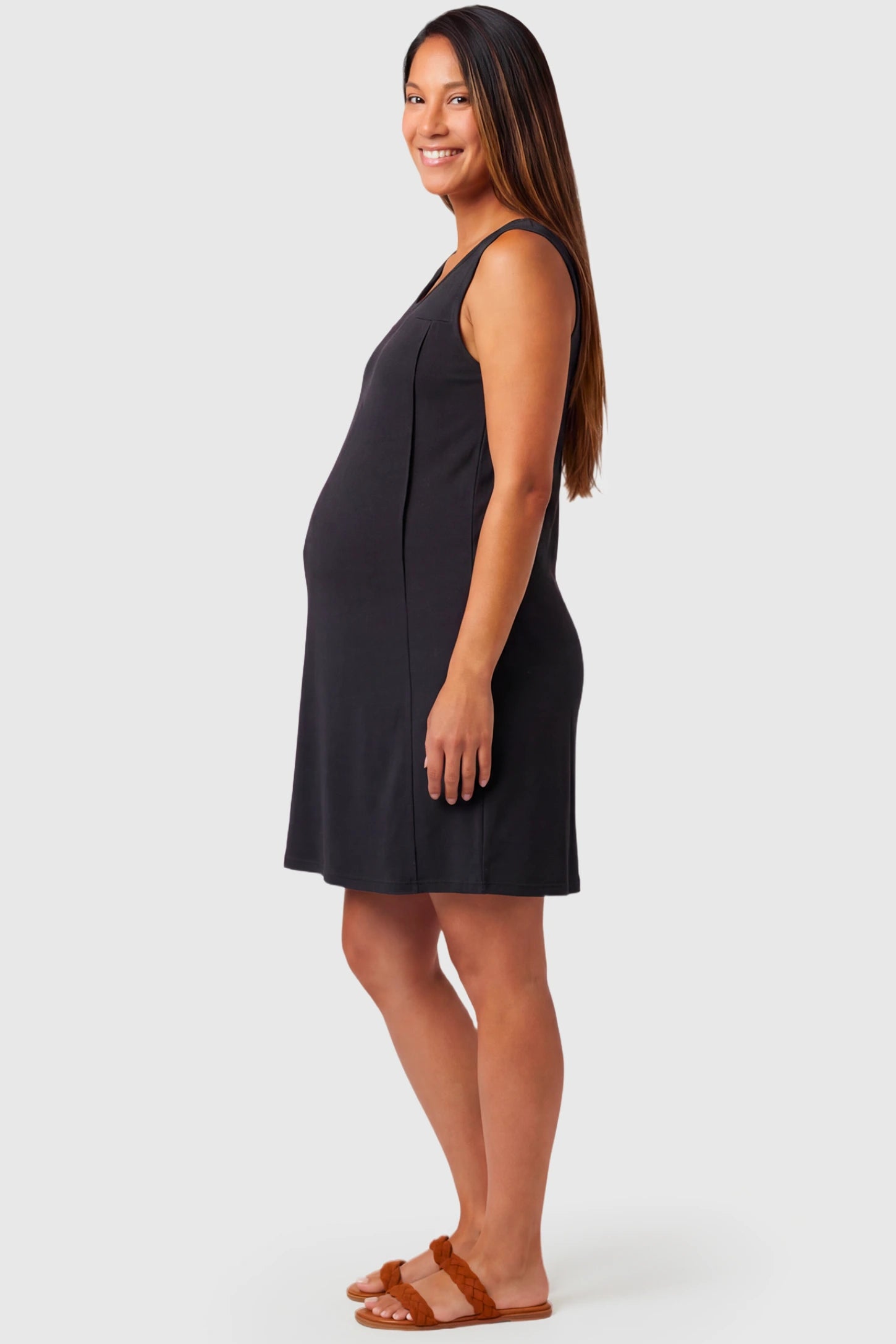 Sleeveless Shift Maternity & Nursing Short Dress Sleeveless Shift Maternity & Nursing Short Dress in black featuring a relaxed shift silhouette and crew neck on a pregnant model.