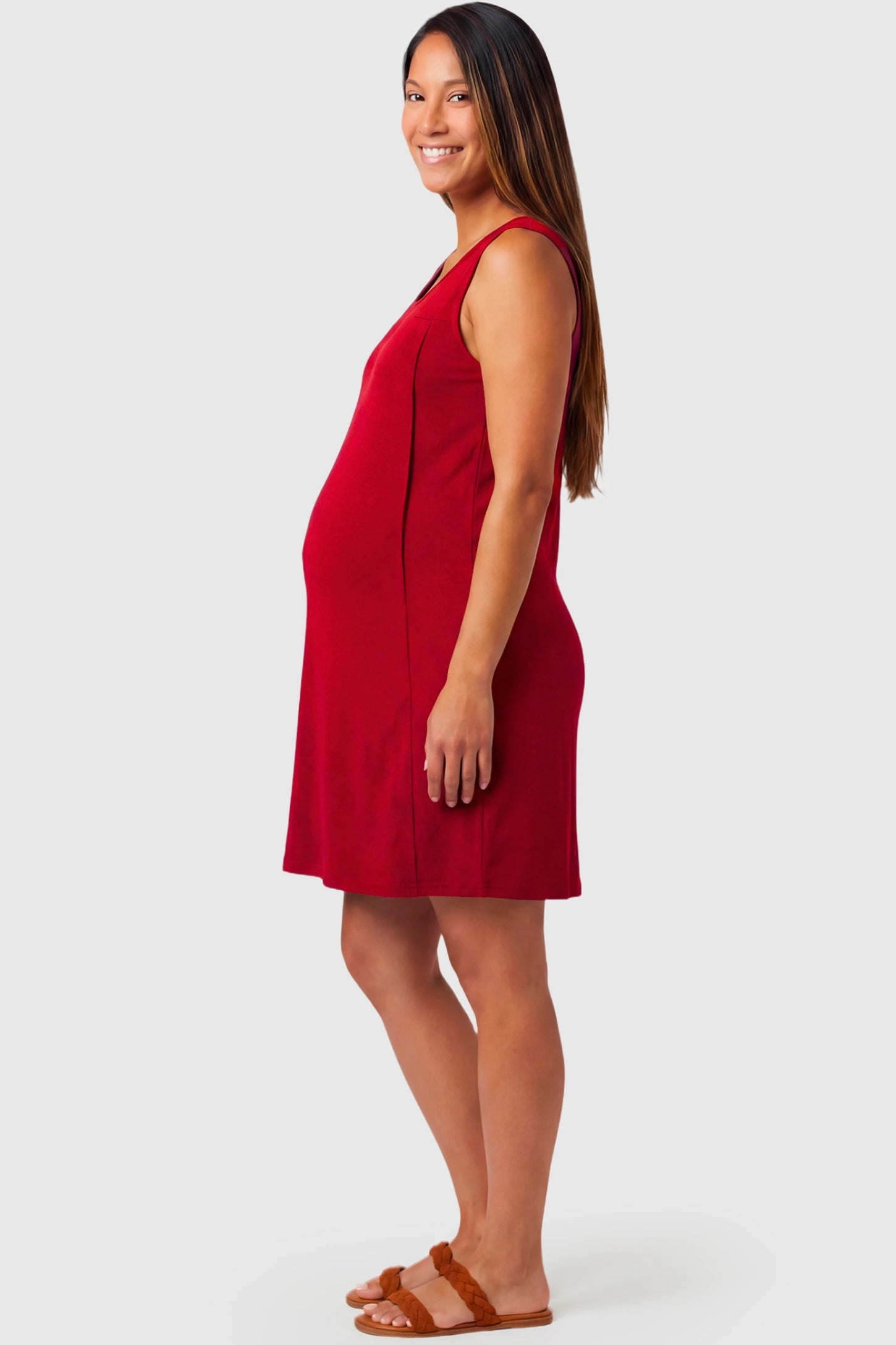 Sleeveless Shift Maternity & Nursing Short Dress in red featuring a relaxed shift silhouette and crew neck on a pregnant model.