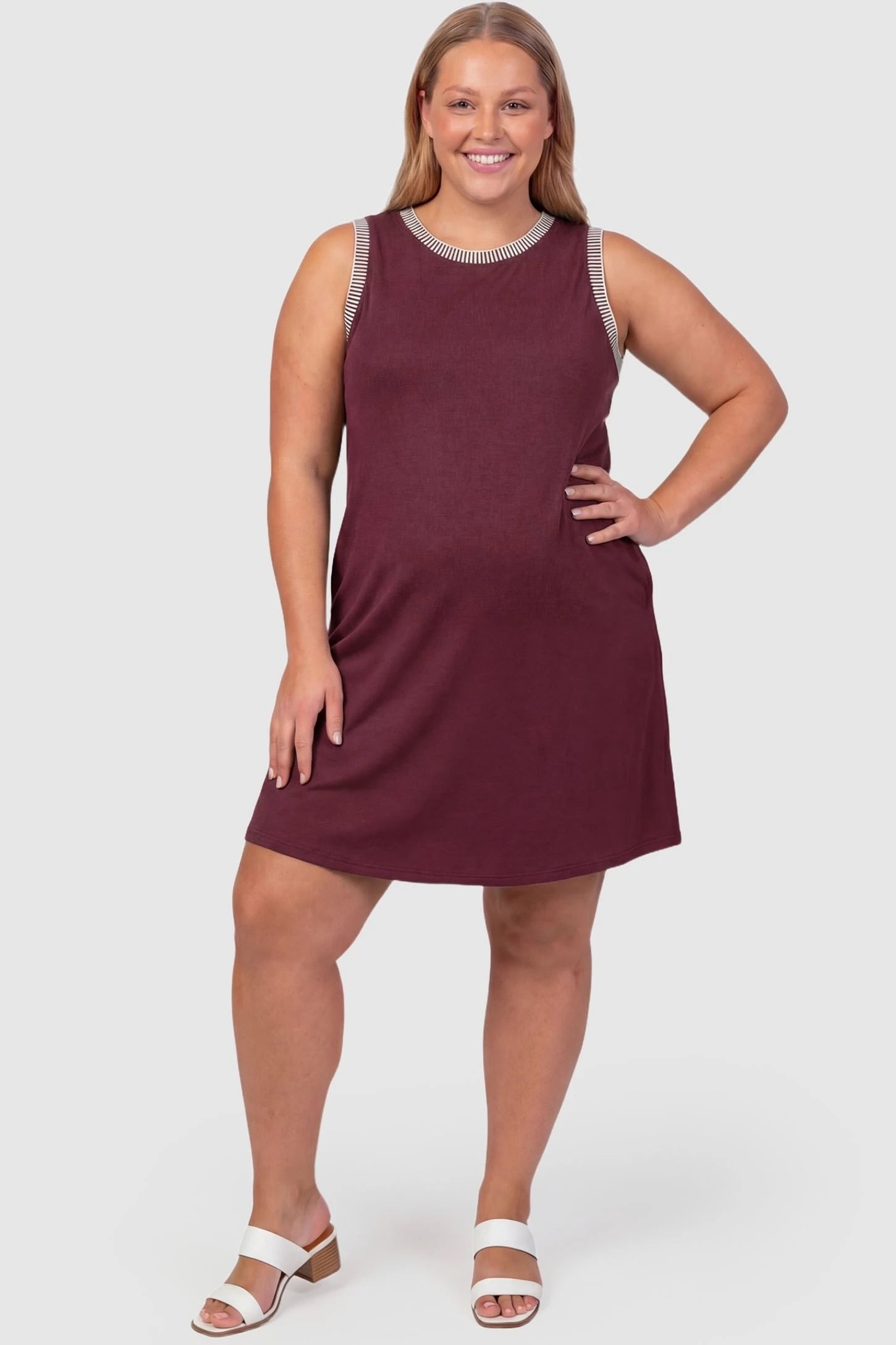 Sleeveless Round Neck A-Line Short Maternity Dress Sleeveless round neck A-line short maternity dress in burgundy featuring umbrella skirt silhouette in full body view on a plus-size model