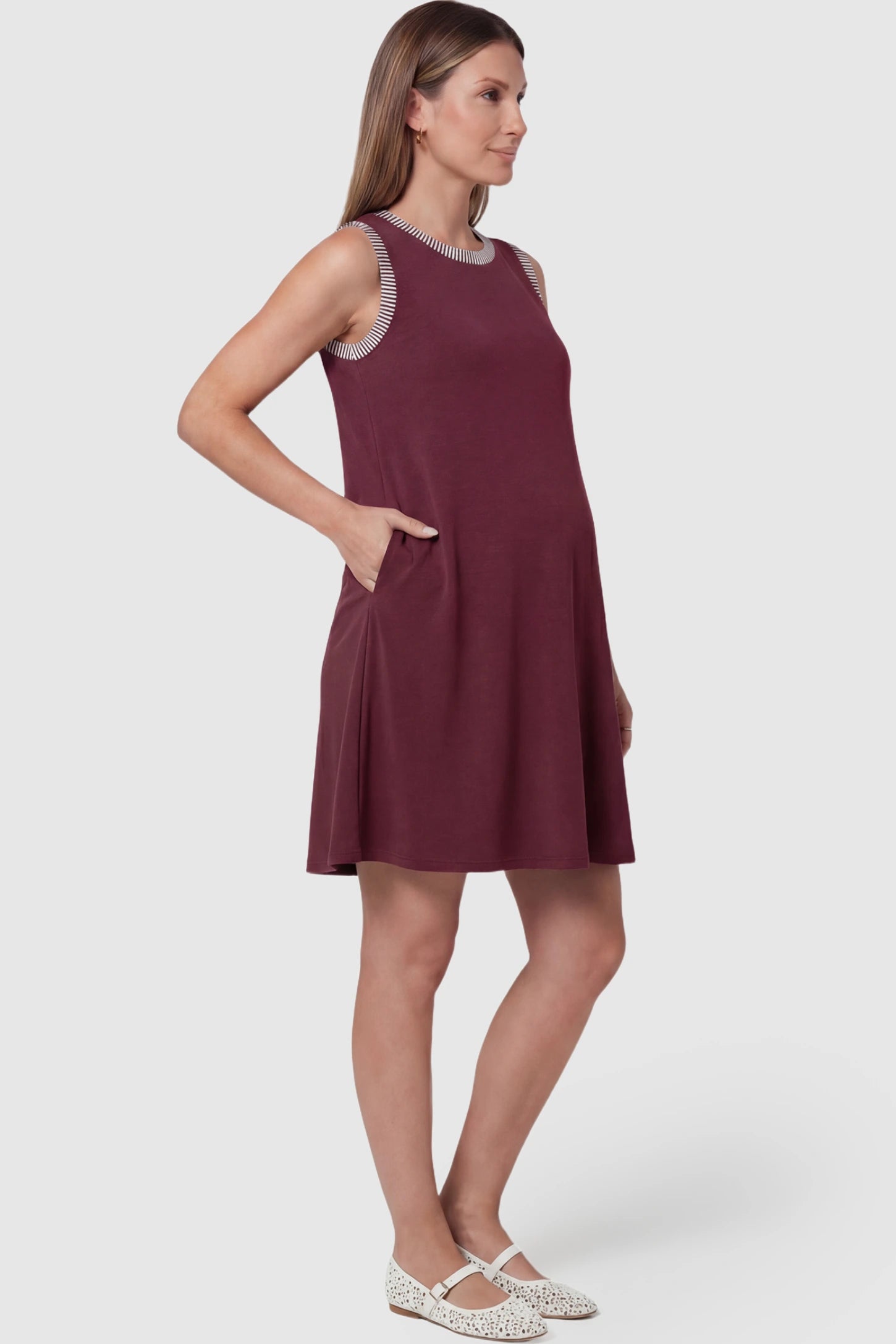 Sleeveless A-Line Maternity Mini Dress Sleeveless A-Line Maternity Short Dress in burgundy featuring sleeveless cut in side view on a pregnant model