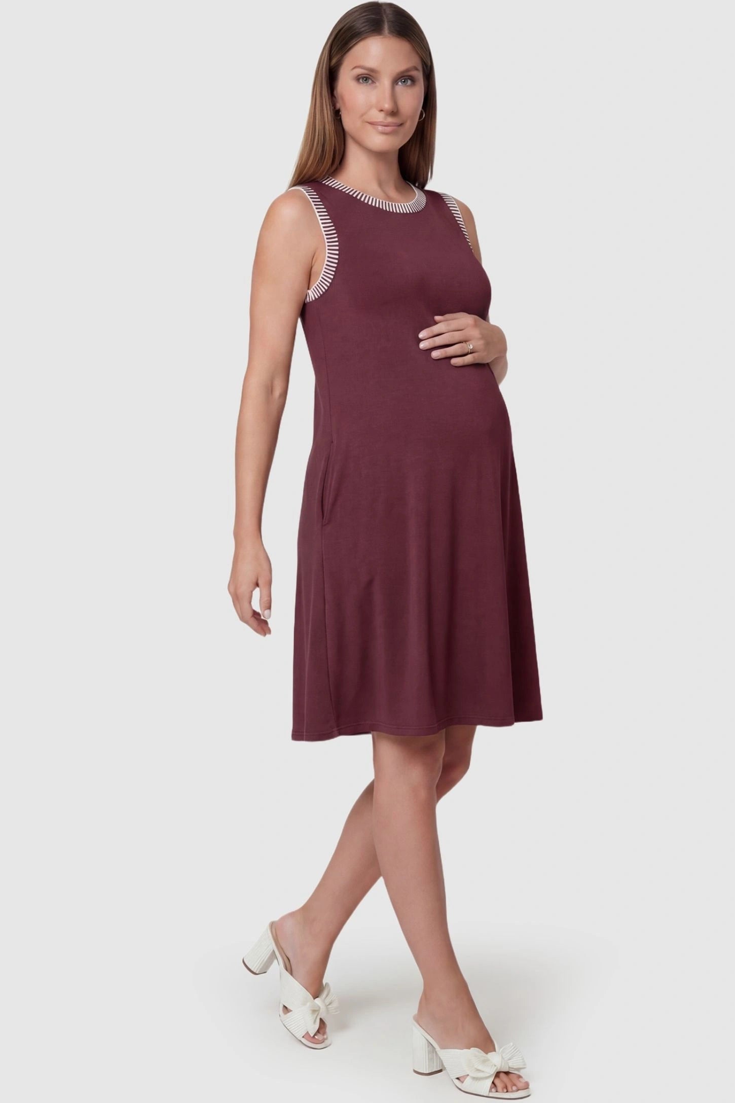 Sleeveless Round Neck A-Line Short Maternity Dress Sleeveless round neck A-line short maternity dress in burgundy featuring umbrella skirt silhouette in full body view on a pregnant model
