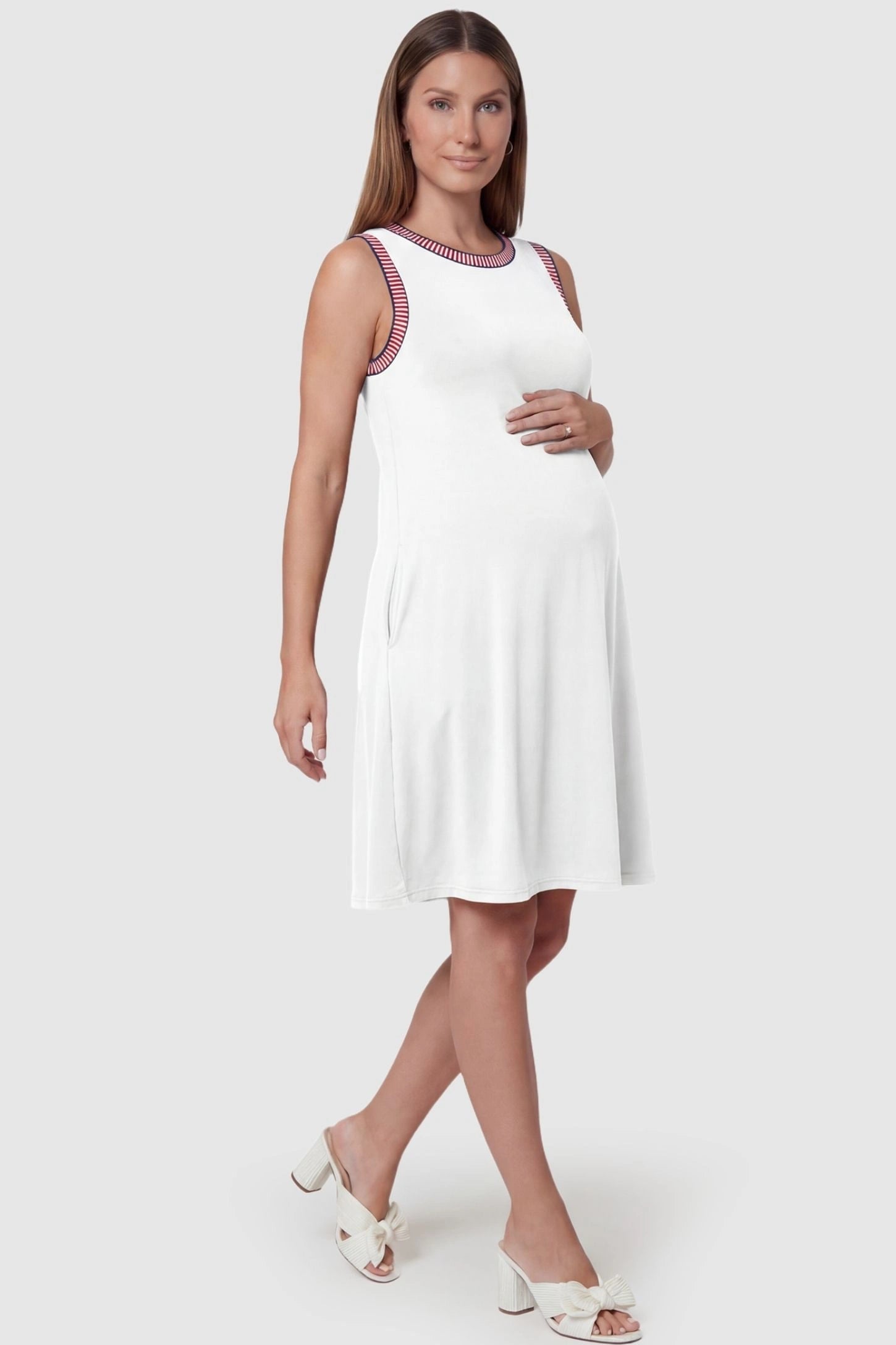 Sleeveless Round Neck A-Line Short Maternity Dress Sleeveless round neck A-line short maternity dress in white featuring umbrella skirt silhouette in full body view on a pregnant model