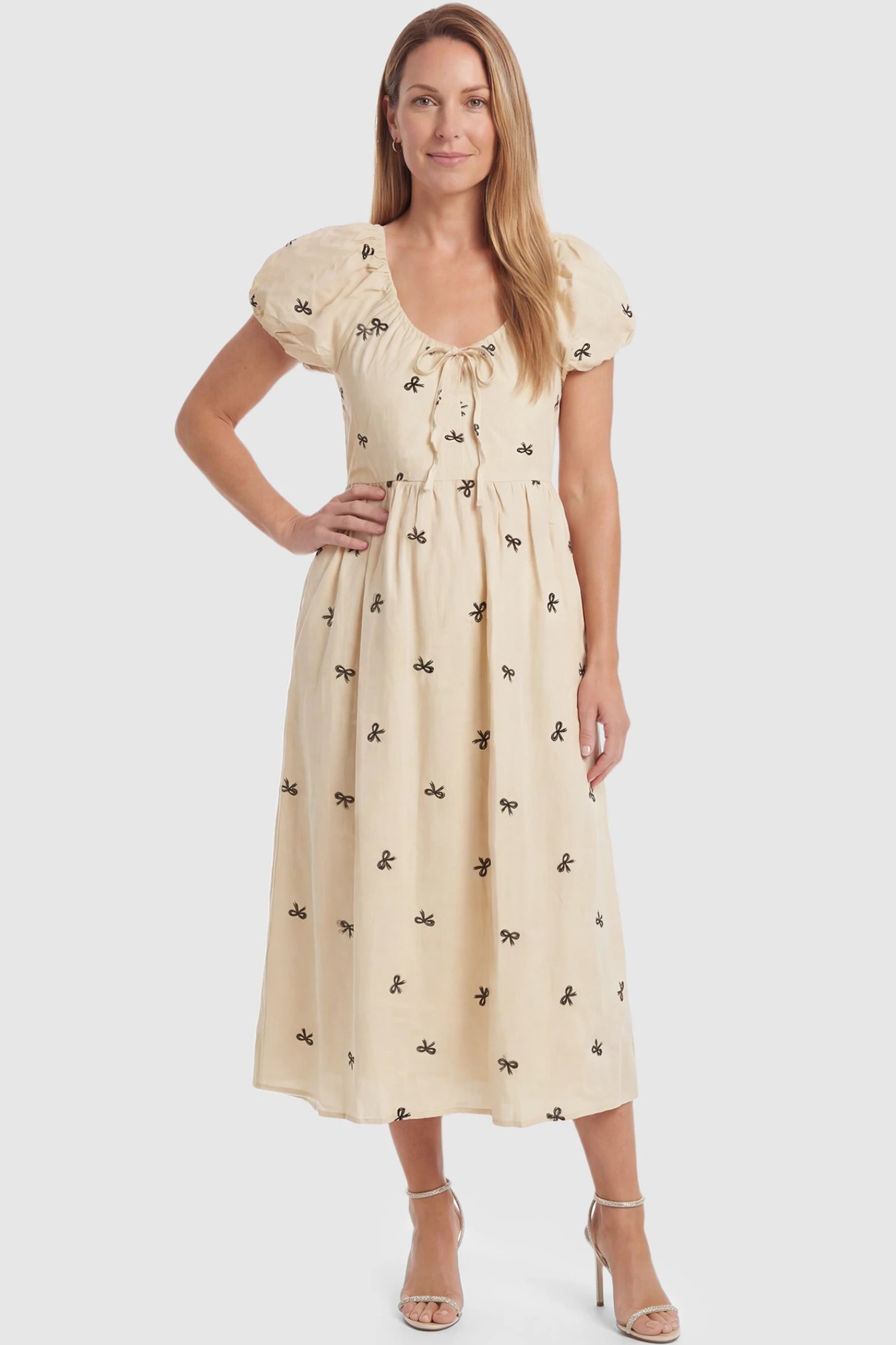 Bow Print Drawstring Neck Maternity Midi Dress Bow print drawstring neck maternity midi dress in beige with drawstring neckline detail, front view on postpartum model